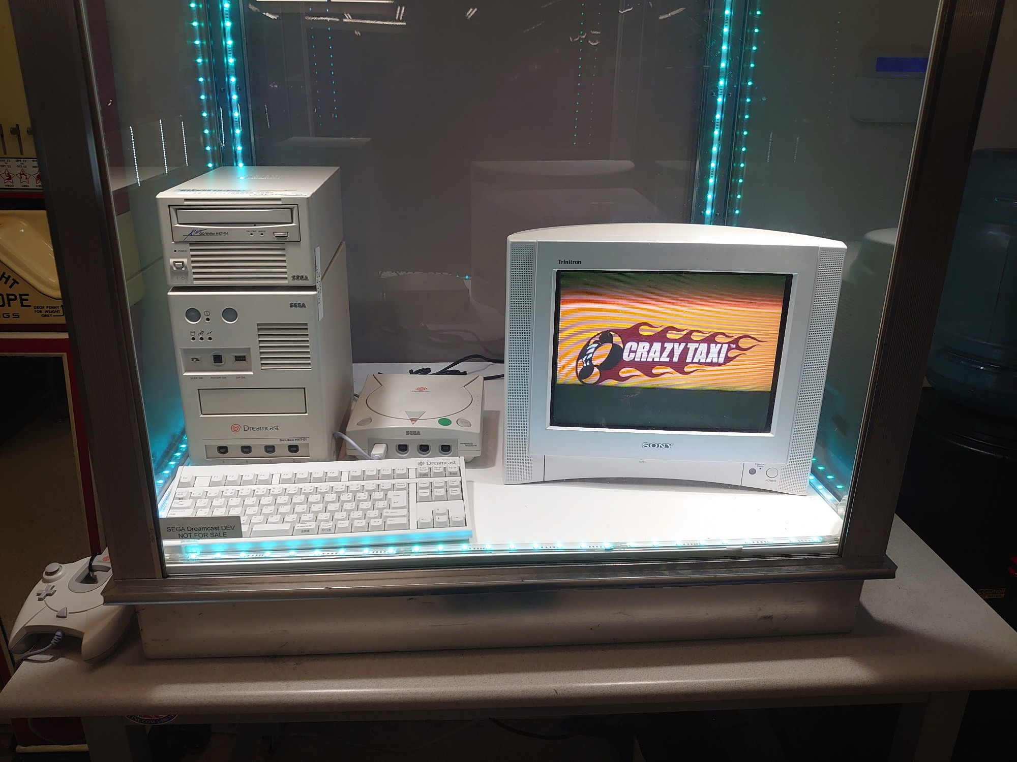 Sega Dreamcast dev kit, console, and a CRT behind a glass case