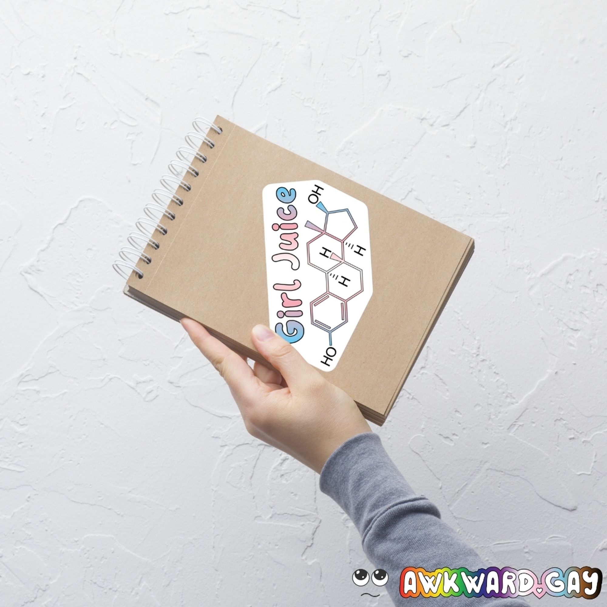 The Girl Juice sticker on a notepad being held up