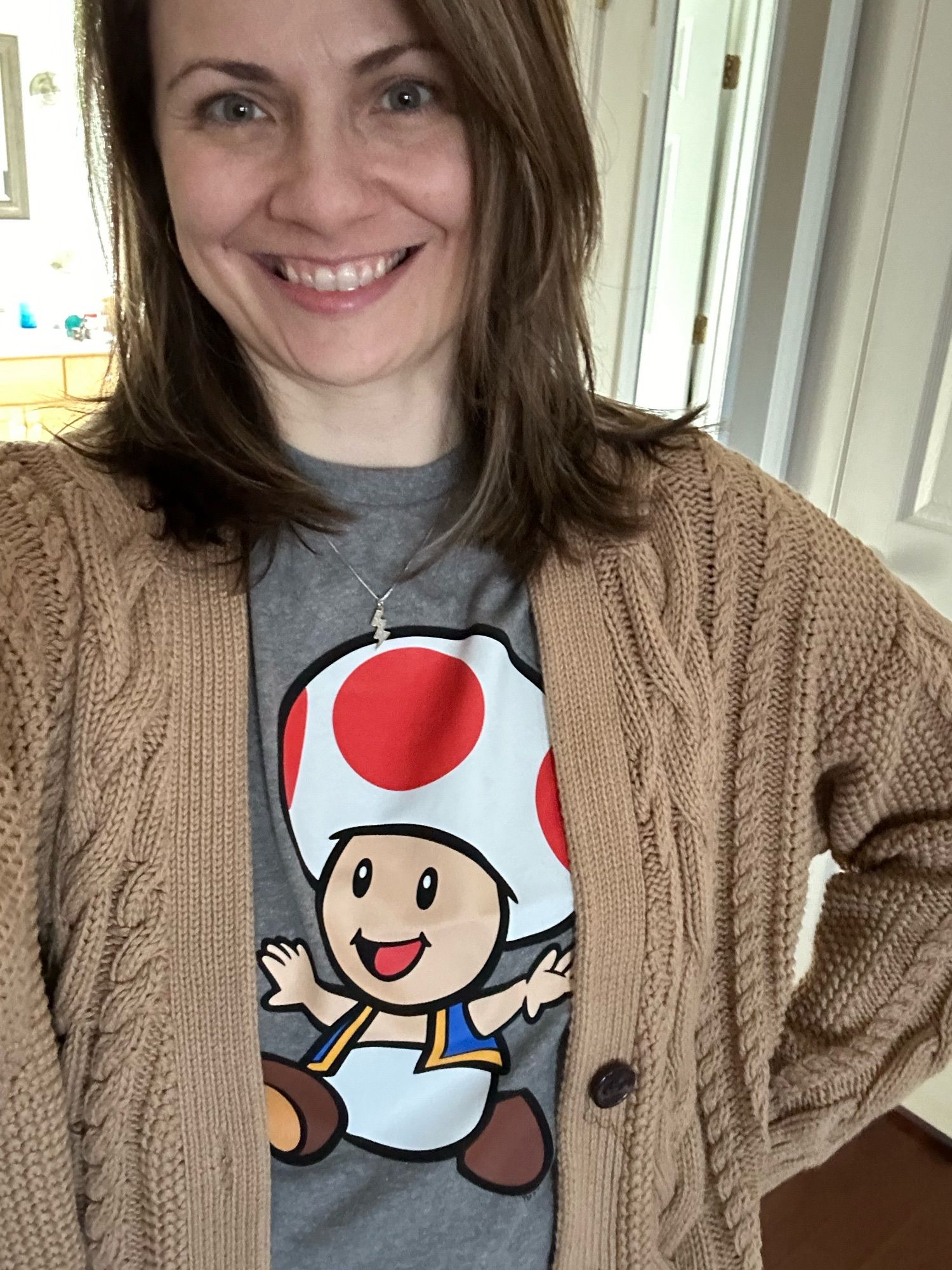 How can you not smile and feel uplifted by this joyful Toad-hatted harbinger of joy??? (A woman wearing a Mario Toad shirt gleefully)