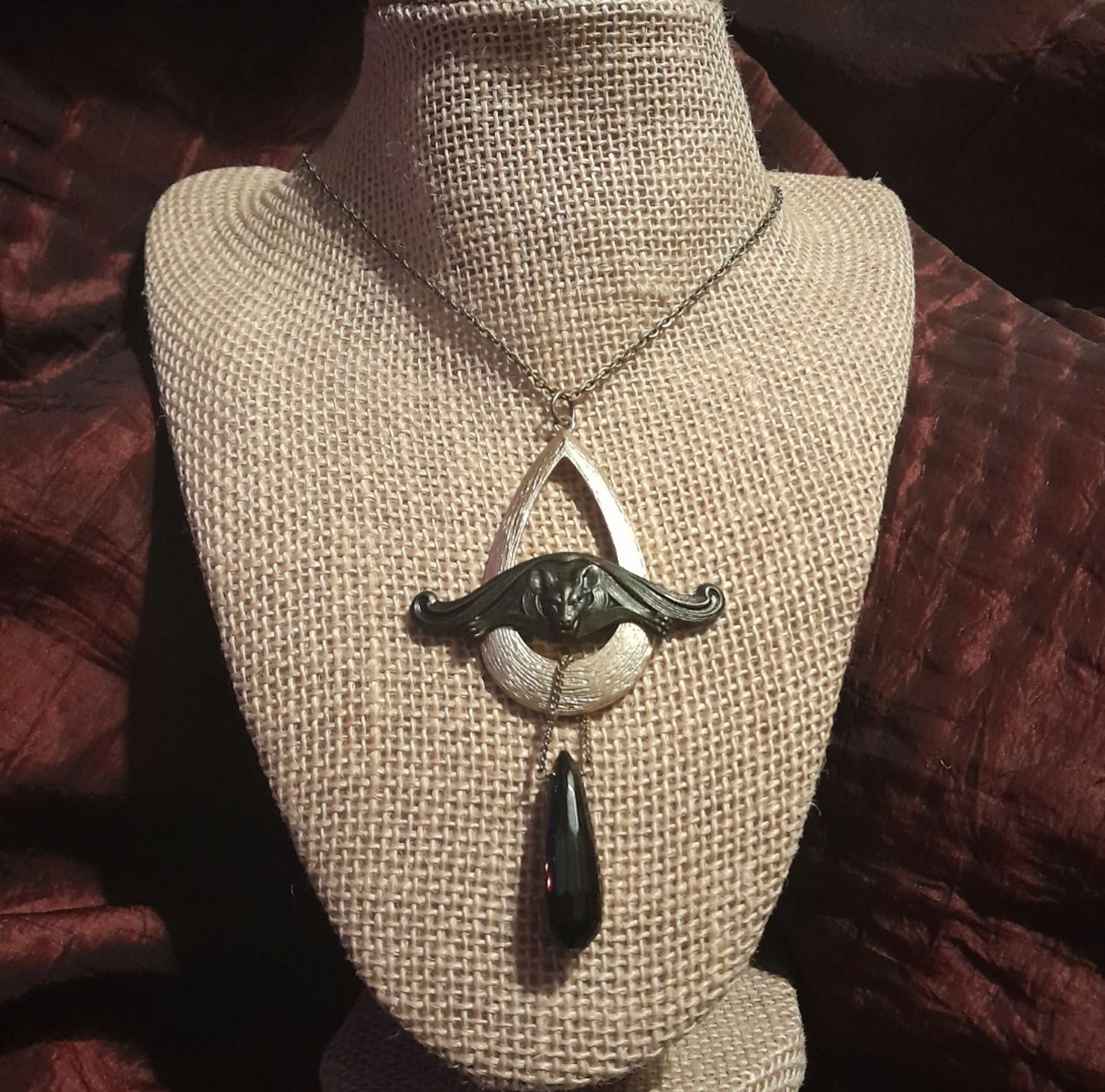 Art Deco teardrop bat necklace on 18 inch brass chain, Blackened brass bat sits wide-winged at the center of an open, light-golden 1960s teardrop pendant with a faceted black resin pendulum from the 1930s below, descending teardrops, bold, one of a kind design!