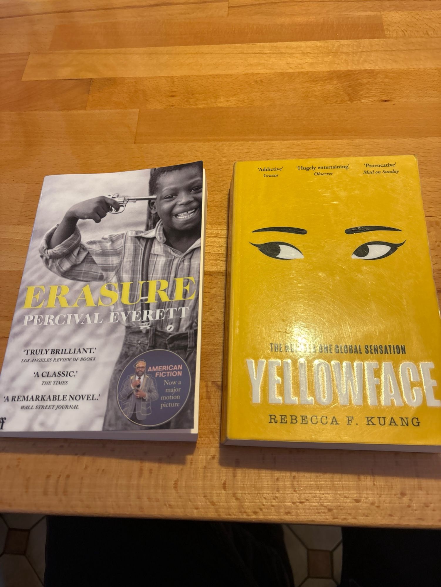 Two books, Erasure by Percival Everett and Yellowface by Rebecca Kuang, side by side on a table.