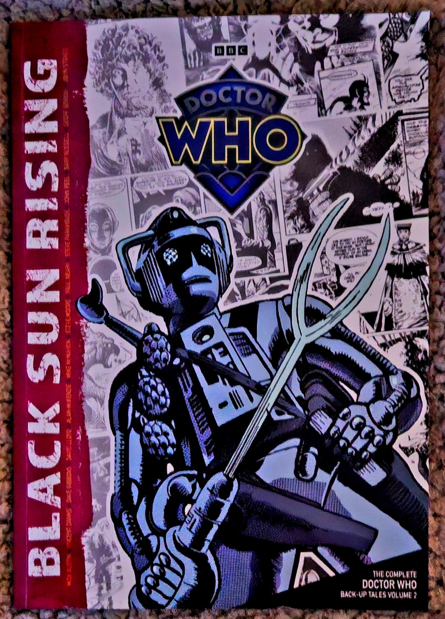 Black Sun Rising: The Complete Doctor Who Back-Up Tales Volume 2 (front cover, depicting Cyberleader Maxel on the planet Goth, against a backdrop of panels of artwork from the stories in the collection)