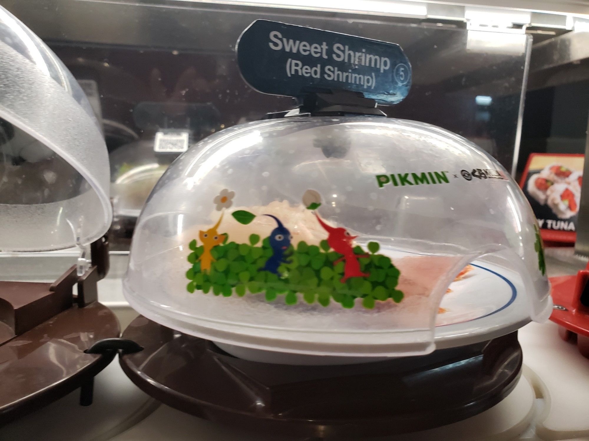 Revolving sushi conveyor belt with decorative pikmin sushi container lids.