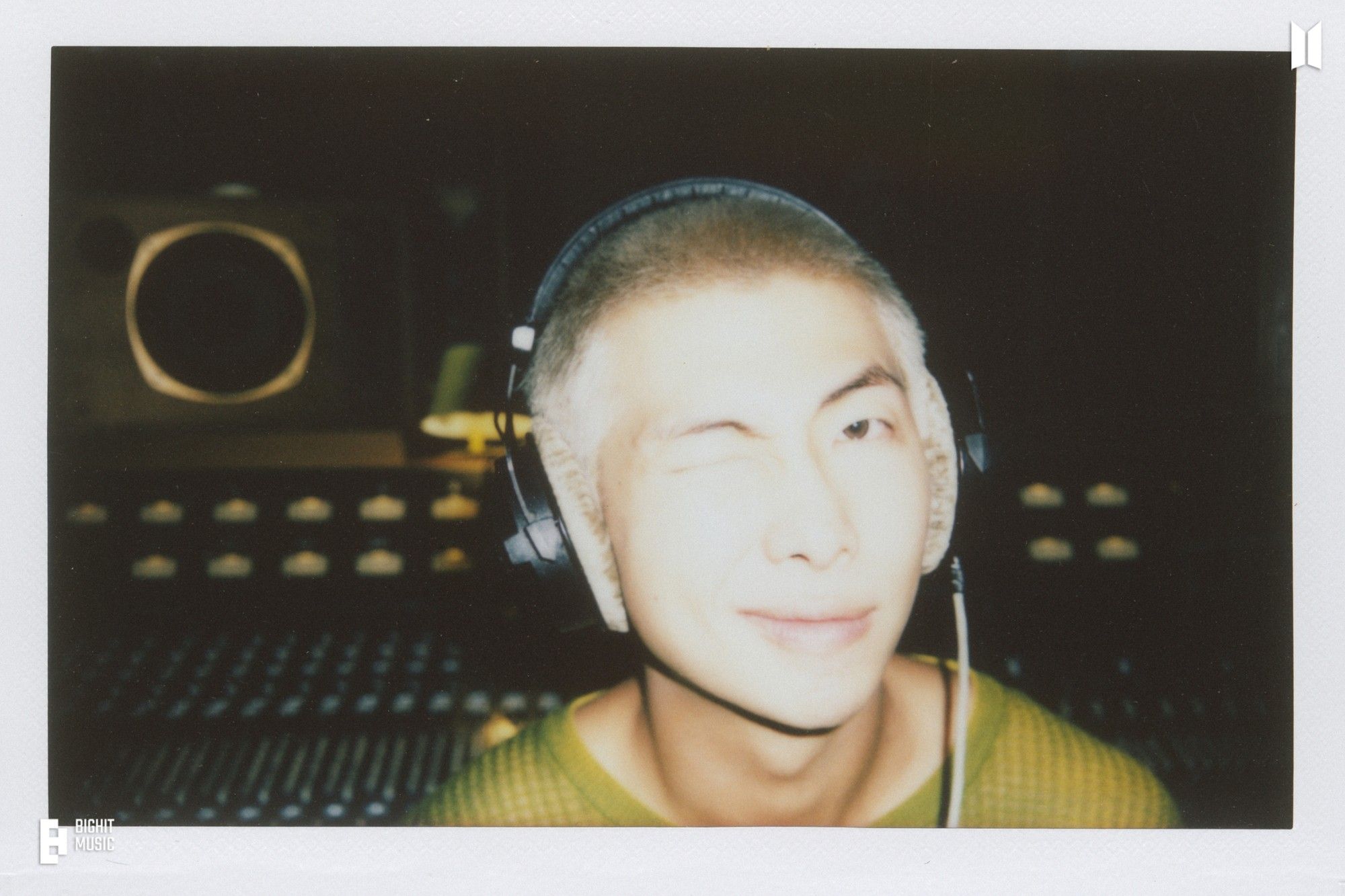 Blonde buzzcut Namjoon wearing big headphone with panels like in the recording studio at the background