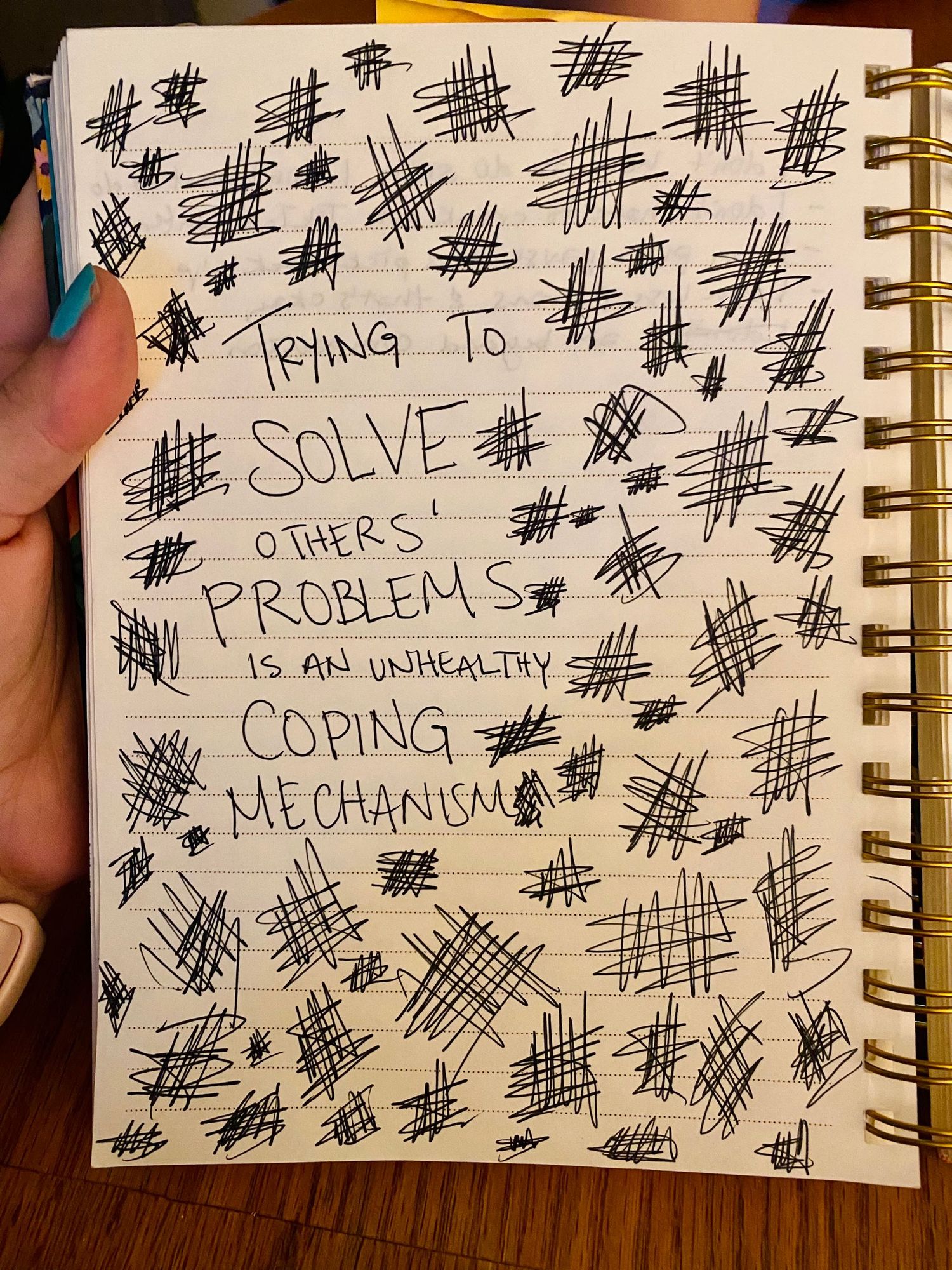 Notebook page with scribbles and text reading “trying to solve others’ problems is an unhealthy coping mechanism”