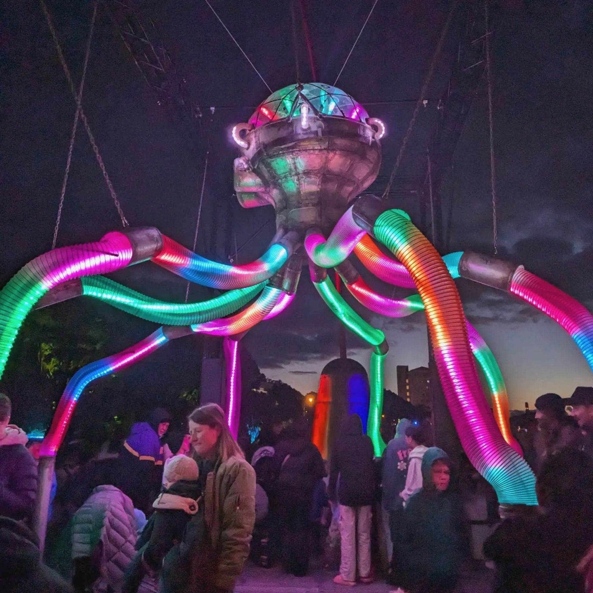 Crowds gathered under a light display shaped like an octopus.