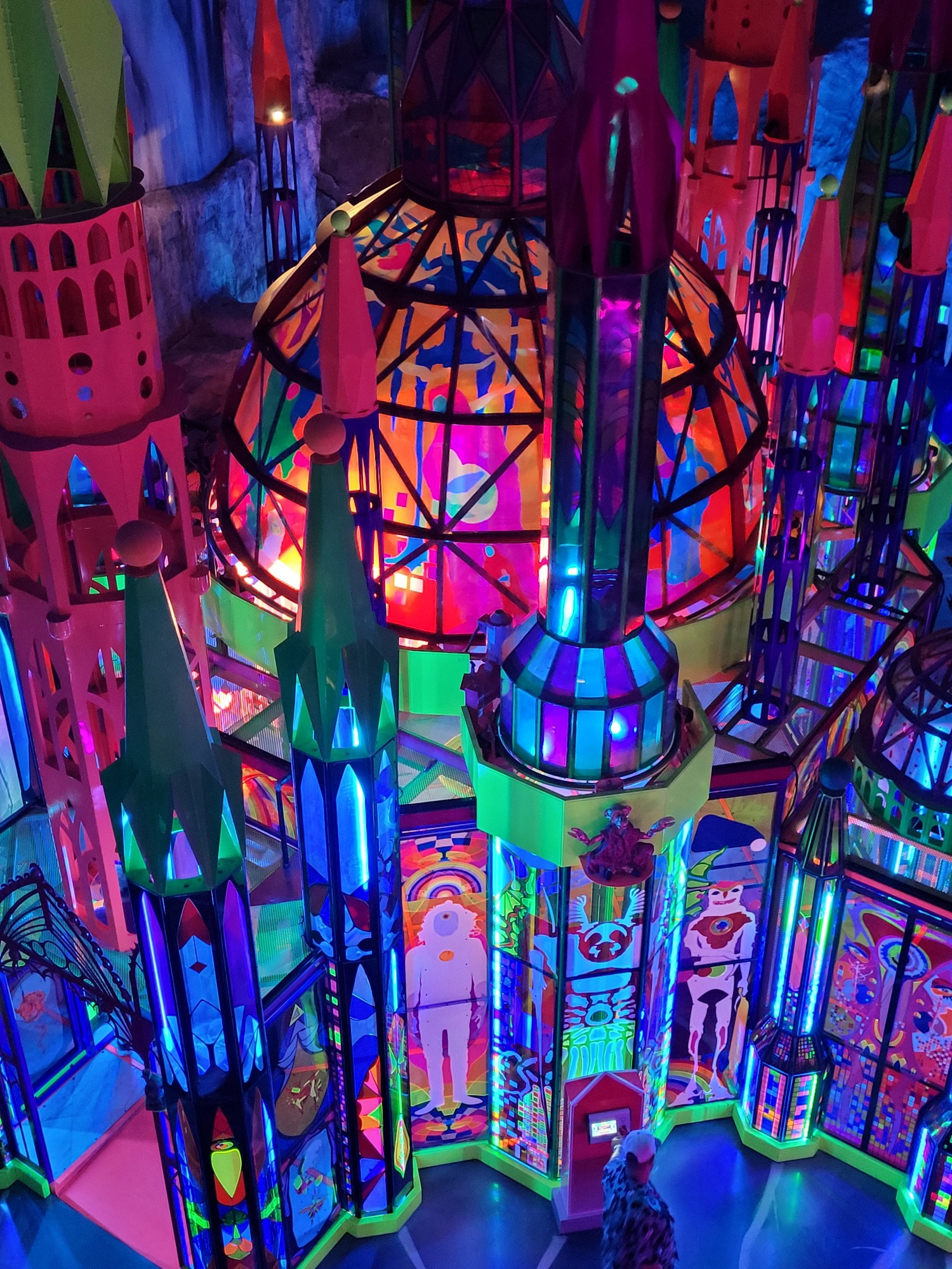 A multi colored, translucent palace/cathedral as seen from above. It has turrets and a dome in the center
