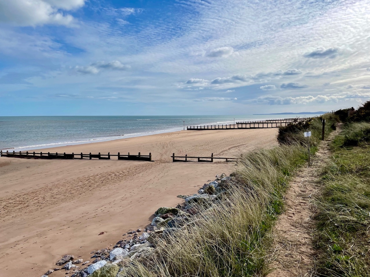 Dawlish Warren on a bright afternoon in early spring, with sky, sea, sand, and dunes