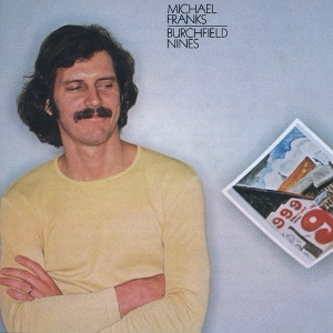 Cover of Michael Franks 1978 album “Burchfield Nines.” He’s at the left of the cover, arms crossed, wearing a yellow sweater; he’s casting glands to the painting to his left, at the right of the album sleeve. The painting shows four red nines in the foreground as they’d appear on grocery signs; behind, a cityscape beneath a blue sky with clouds. 