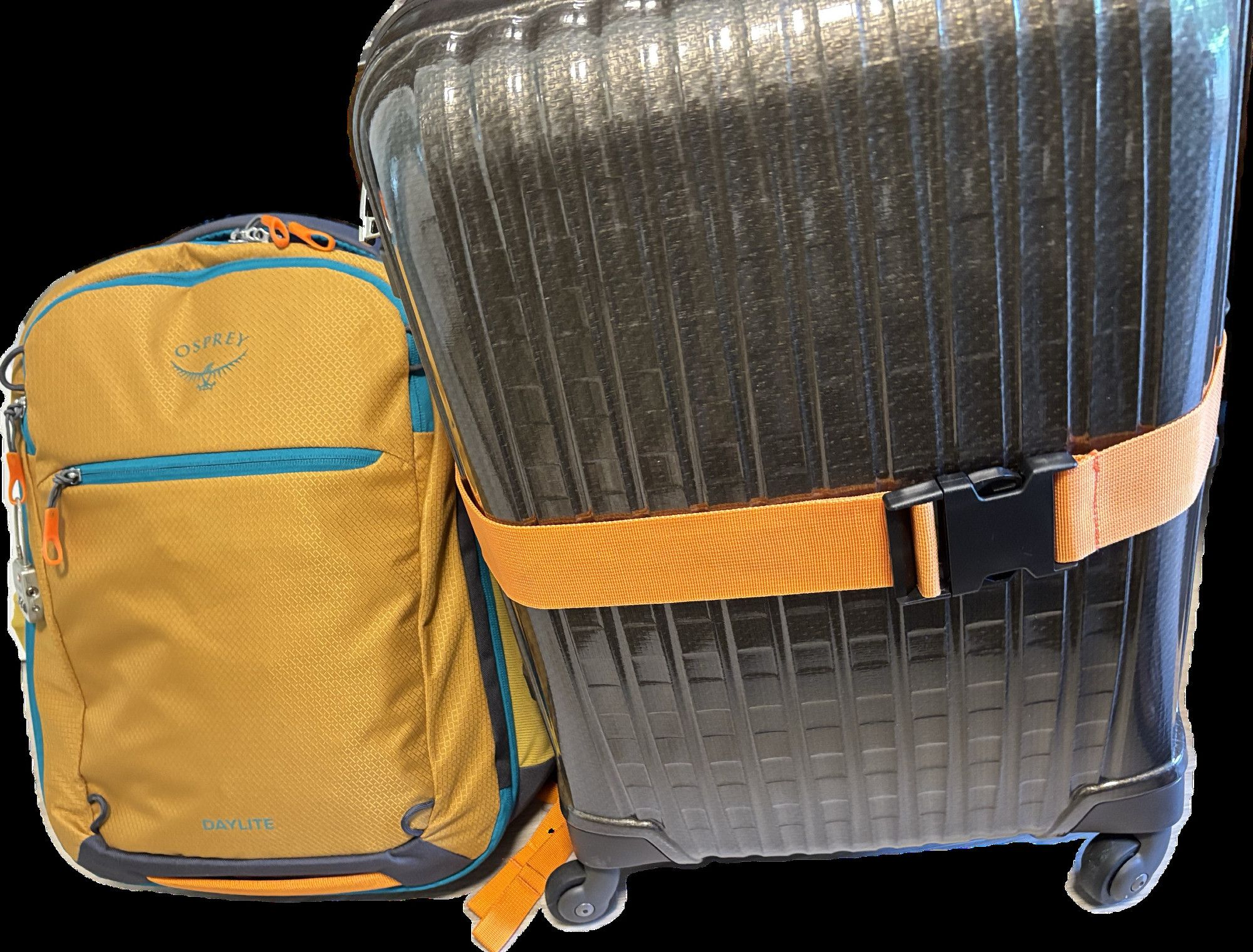 A mustard color with blue and grey piping backpack beside a light brown cabin-sized wheeled suitcase supported by an orange suitcase bra/i.e. luggage strap.