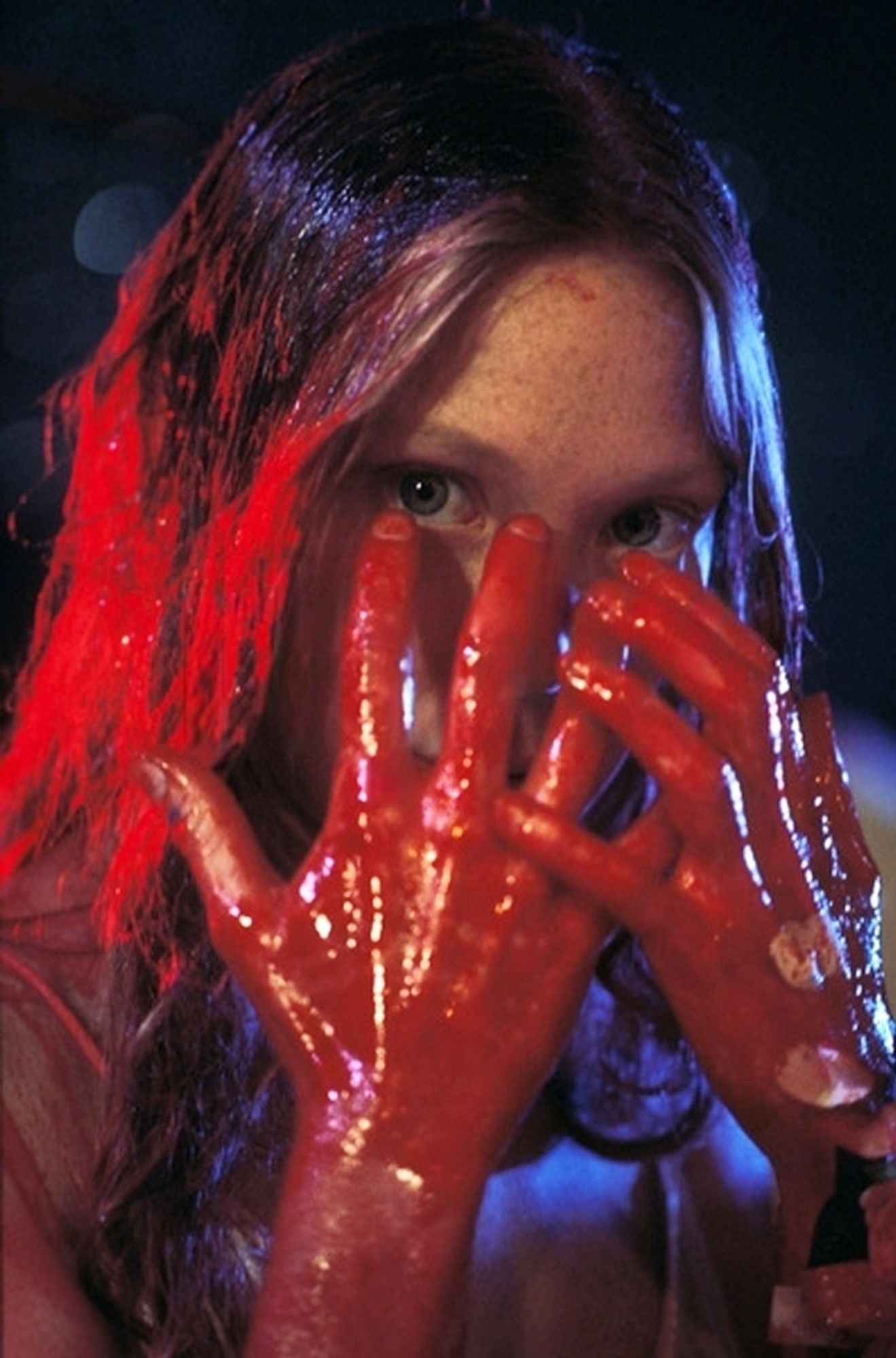 Promotional photograph for the movie Carrie Spacek peeking out at us from behind her blood-soaked hands