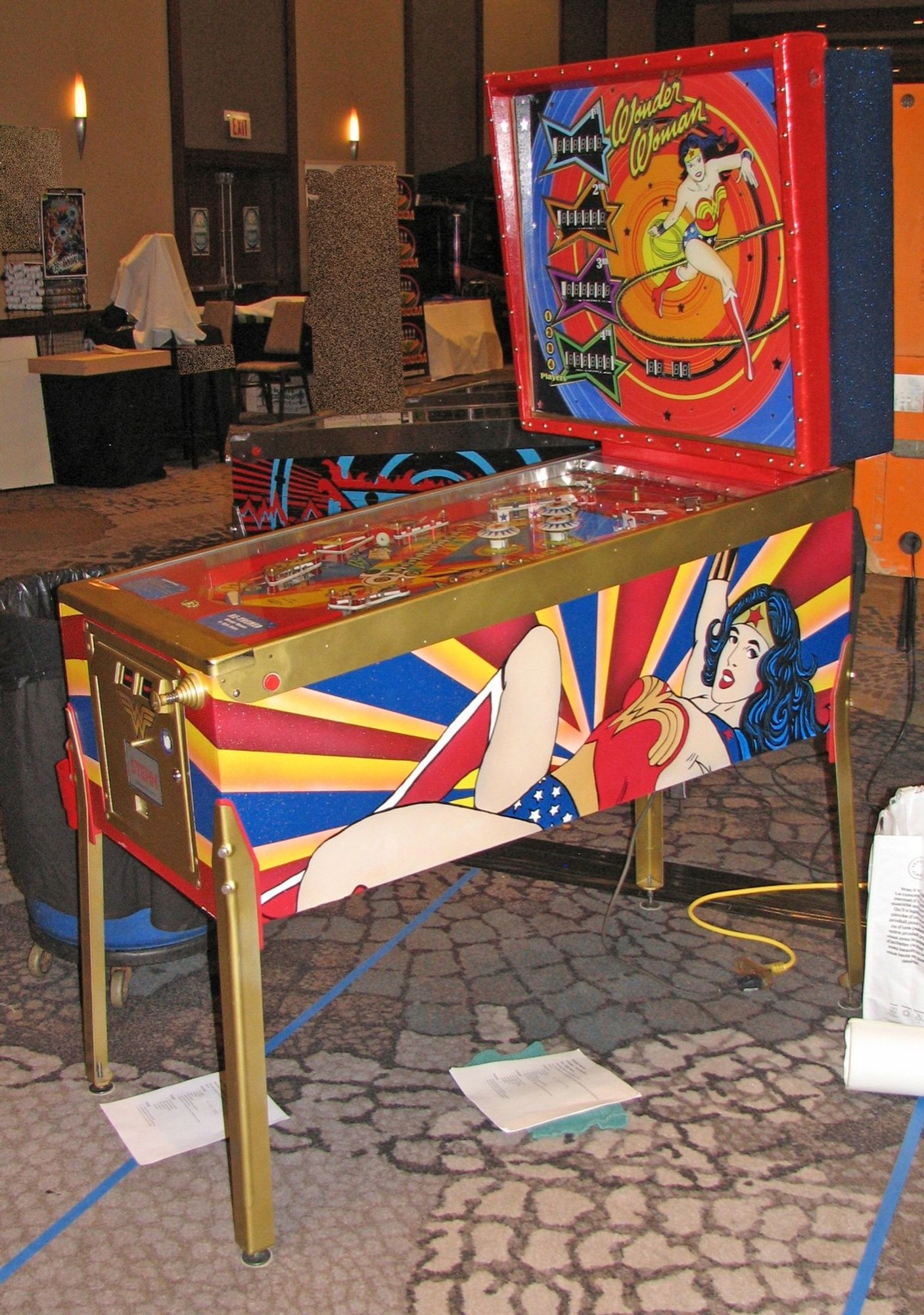 A photograph from off to the side showing the whole machine it's a view on the side of the body of the machine and image of a reclining Wonder Woman