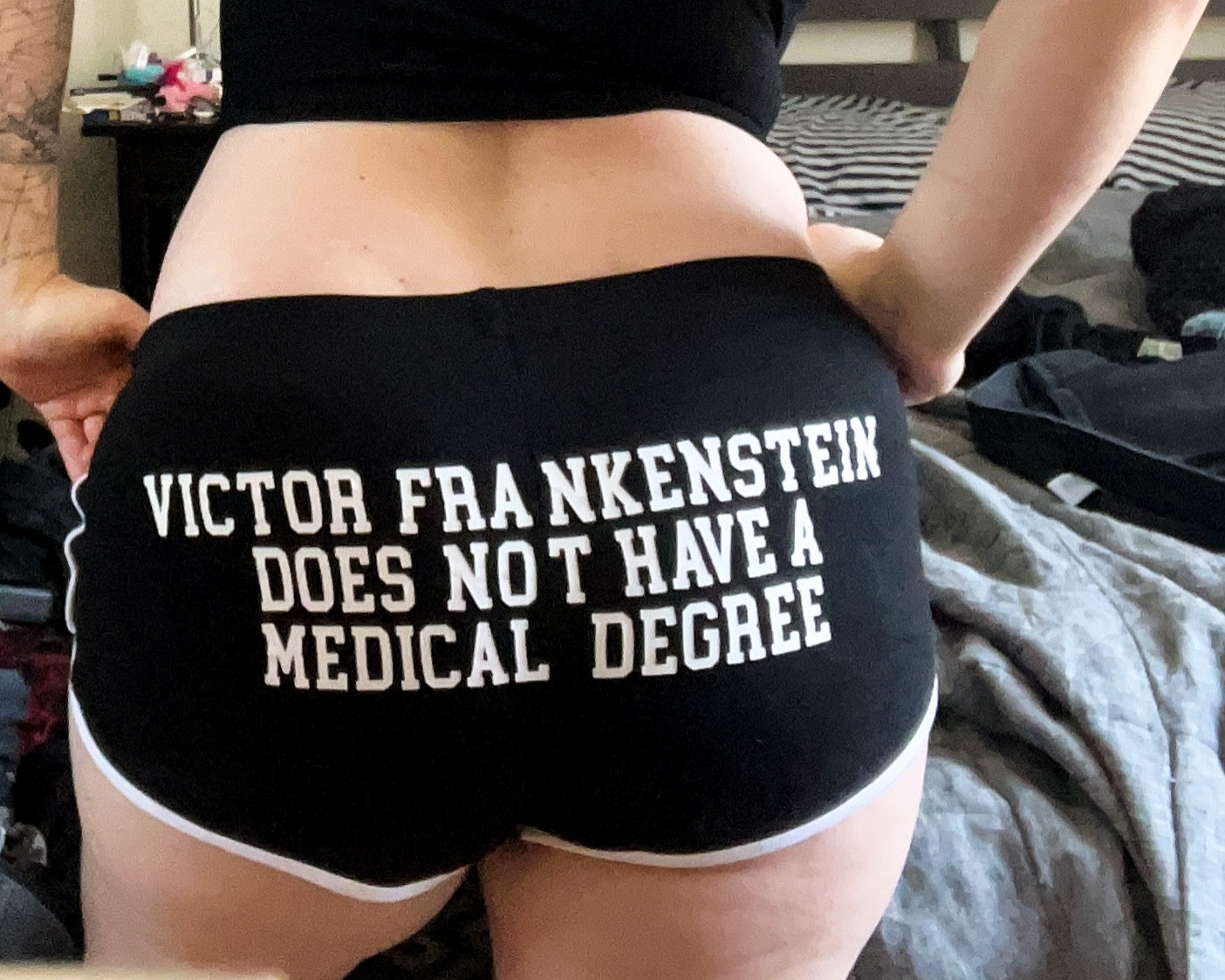 Photograph of a woman wearing booty shorts that say "Victor Frankenstein does not have a medical degree"