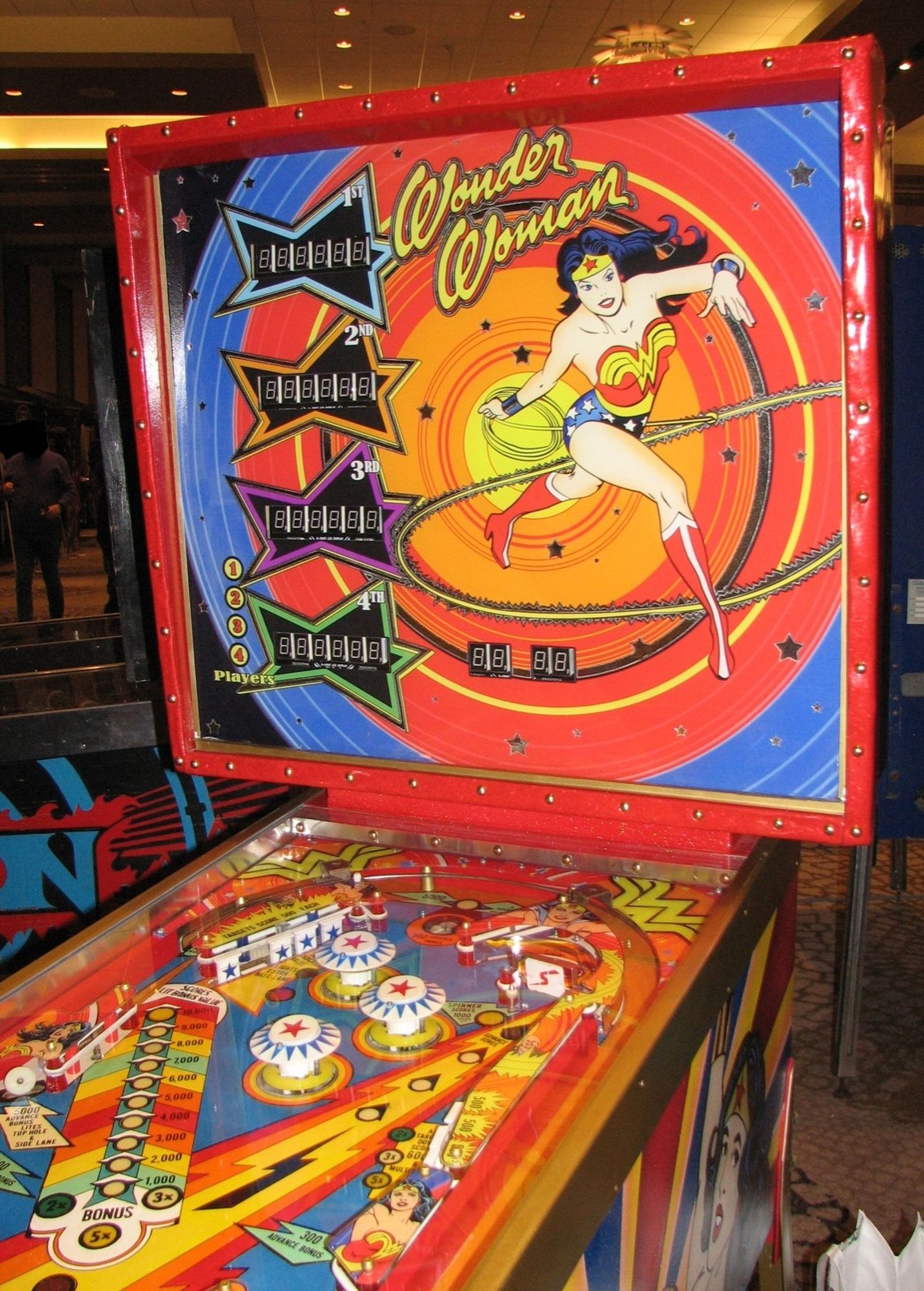 The back glass of a Wonder Woman pinball game Illustrated with a picture of Diana of semicira twirling her lasso apparently this is only a prototype and this game never went to production which is why you've never seen this in an arcade