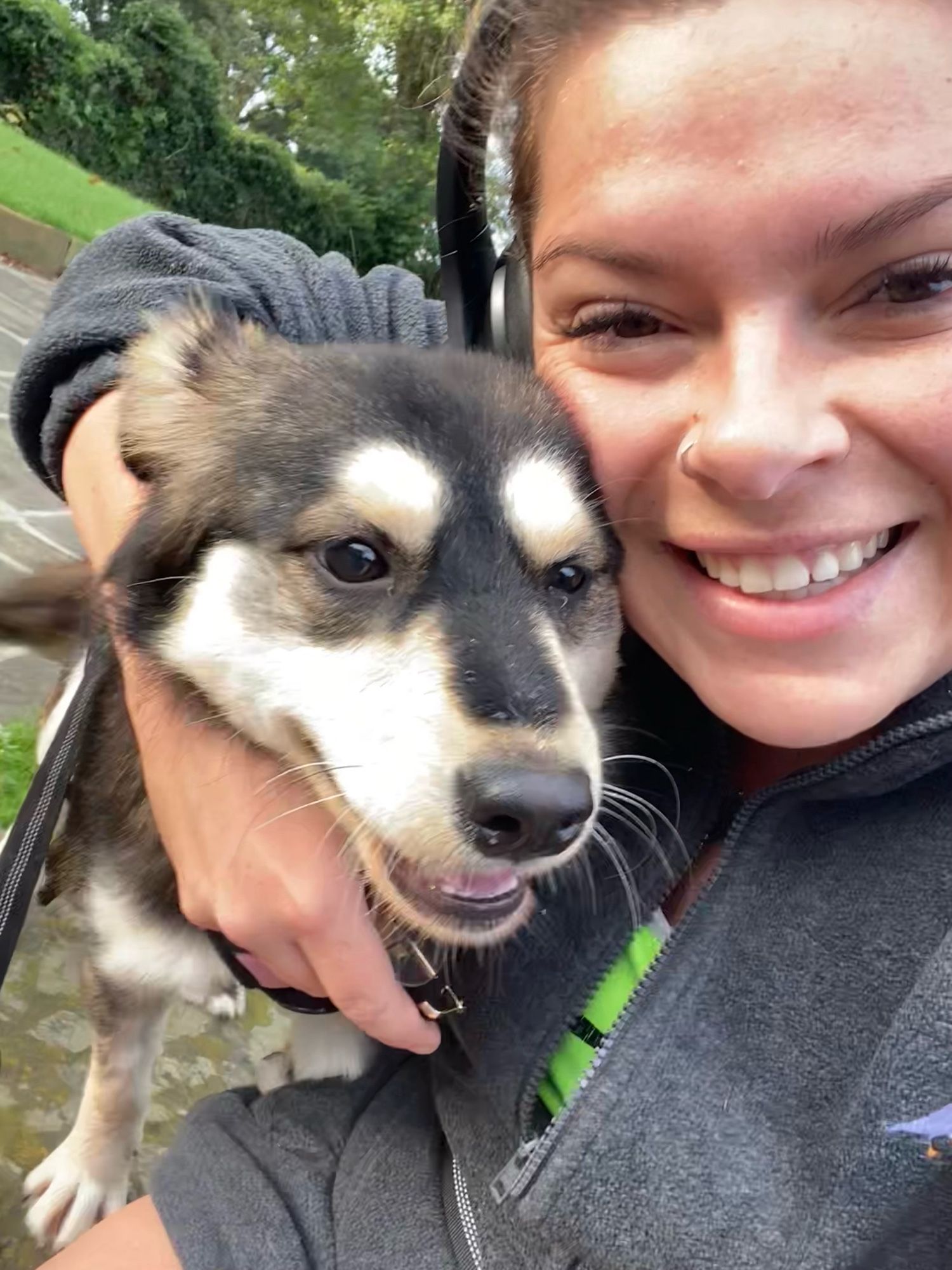 Picture of Nikki and her dog Lyra who has brown, black, and white fur.