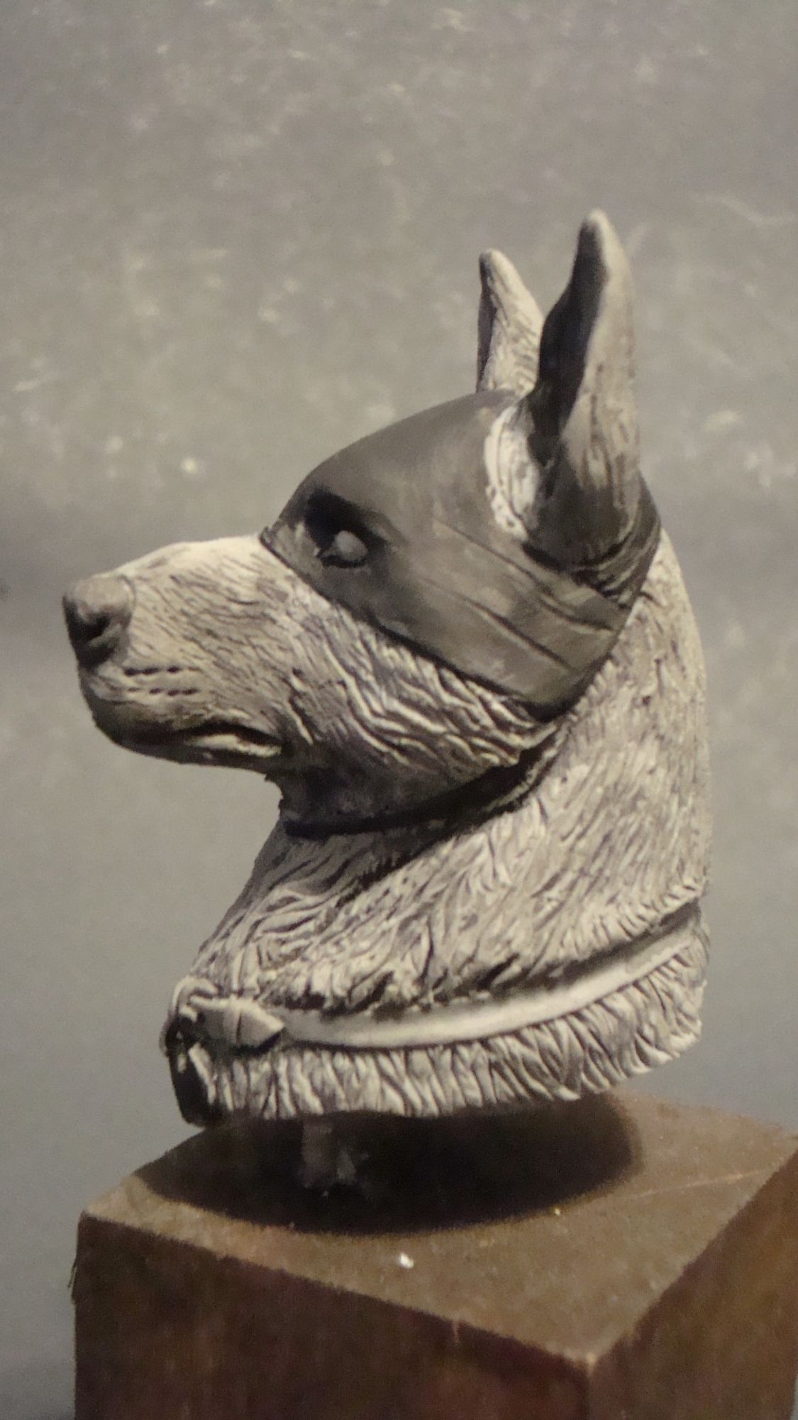 Minibust of Ace the Bathound, a German Shepherd in a mask, left profile view, mounted on a wooden cube