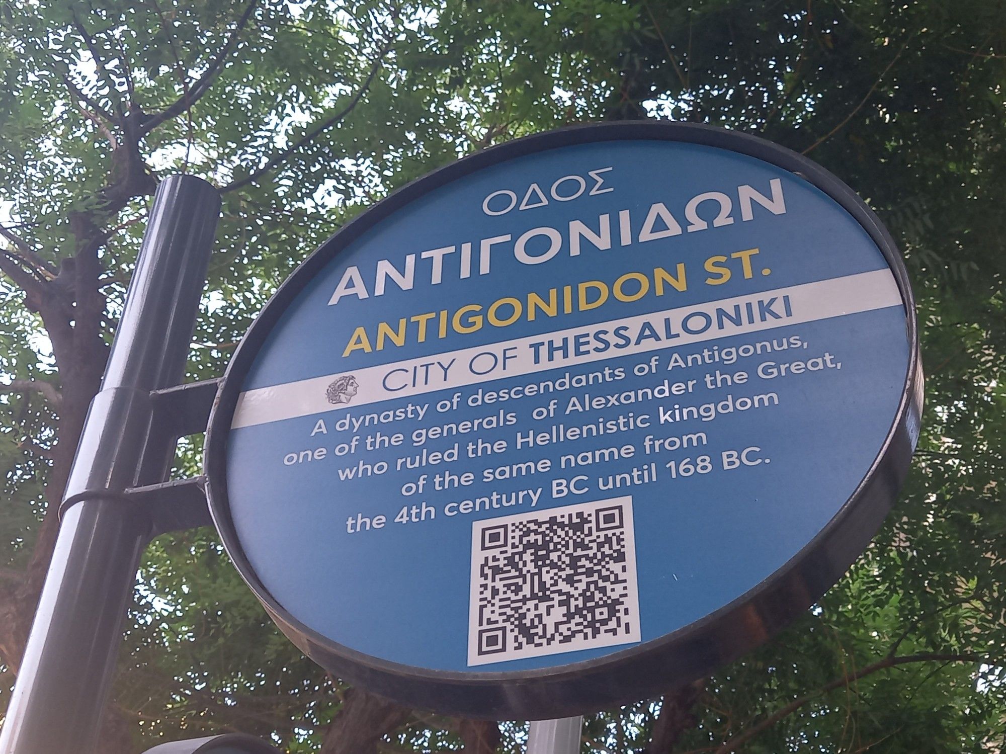 Street sign for Antigonidon Street, in the city of Thessaloniki, explaining that it is named after 'a dynasty of descendants of Antigonus'.