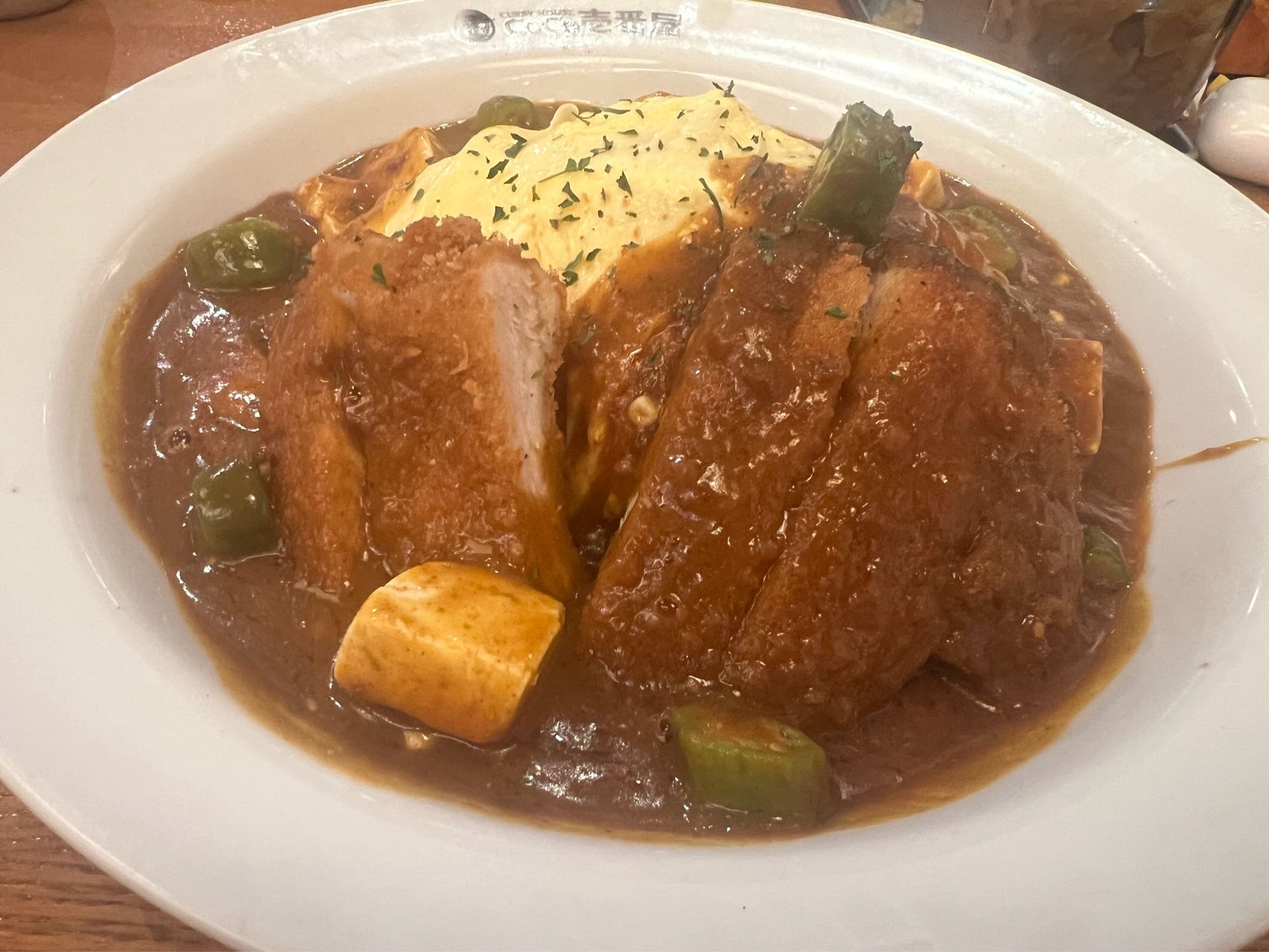 a bowl of katsu curry with okra and veggies spice level 10 coco ichi