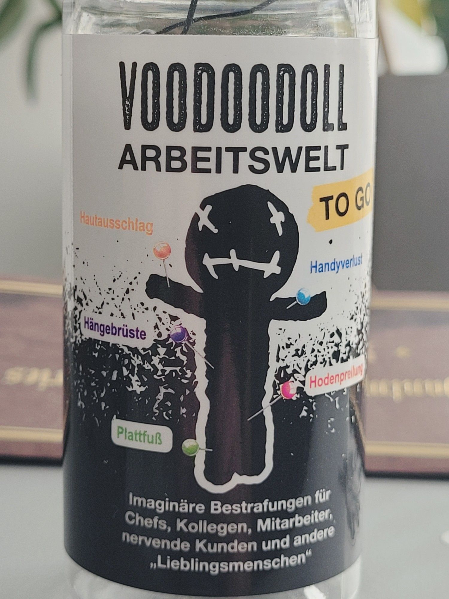 Flasche mit Abbildung der Voodoodoll - Arbeitswelt to go. Beschreibung: Imaginäre Bestrafungen für Chefs, Kollegen, Mitarbeiter, nervende Kunden und andere "Lieblinsmenschen".