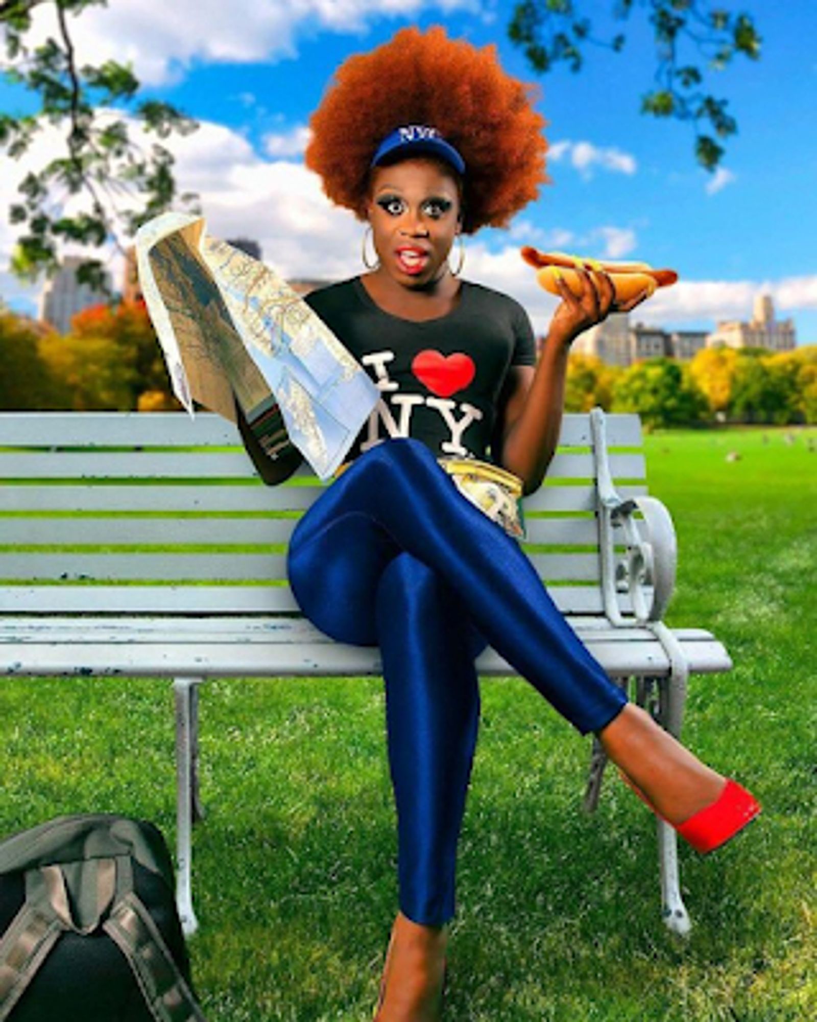 Bob The Drag Queen sitting on a bench with a hotdog in hand