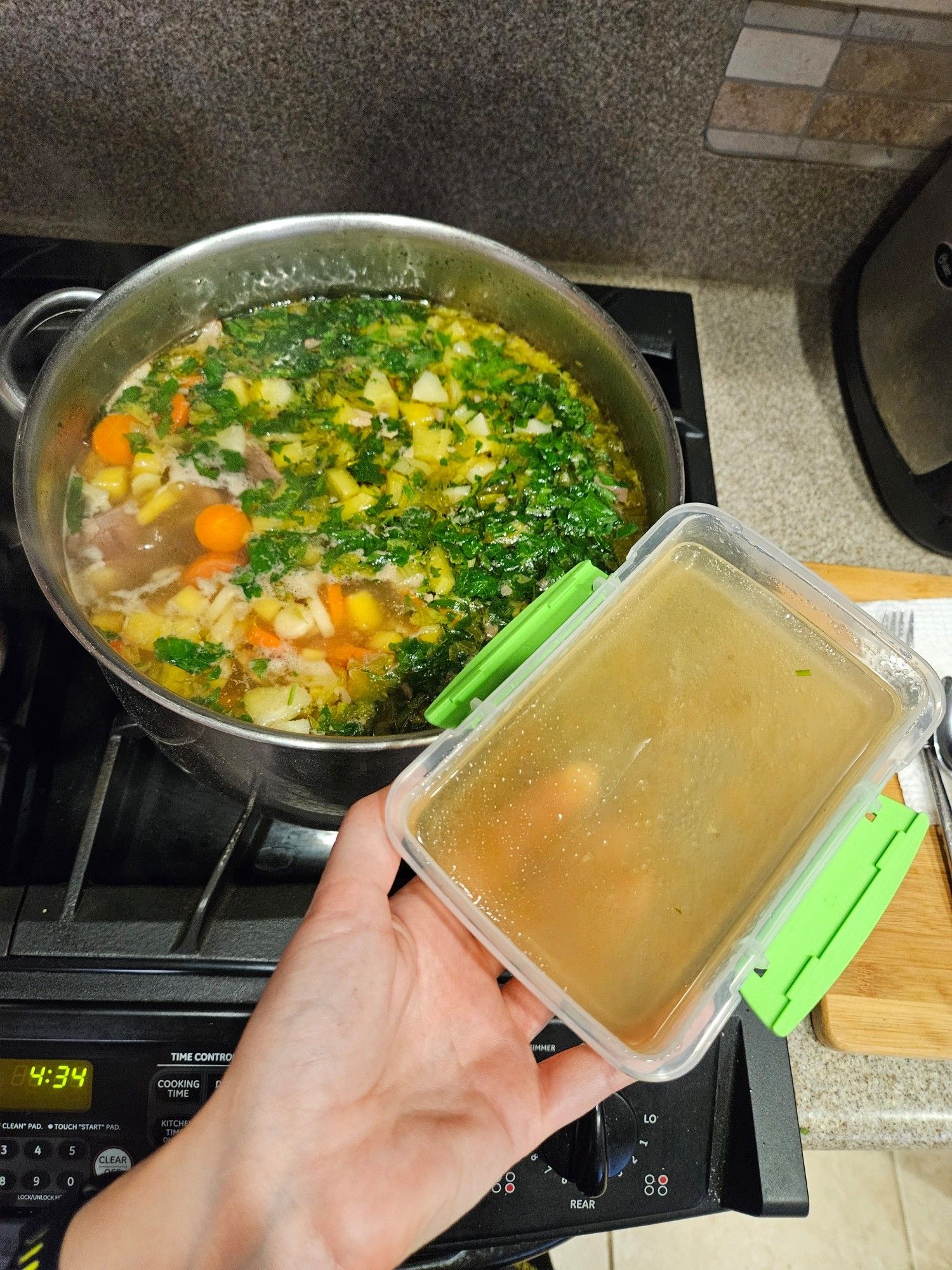 Photo of aliquotted broth into a sterile tupperware with The Soup in the background.