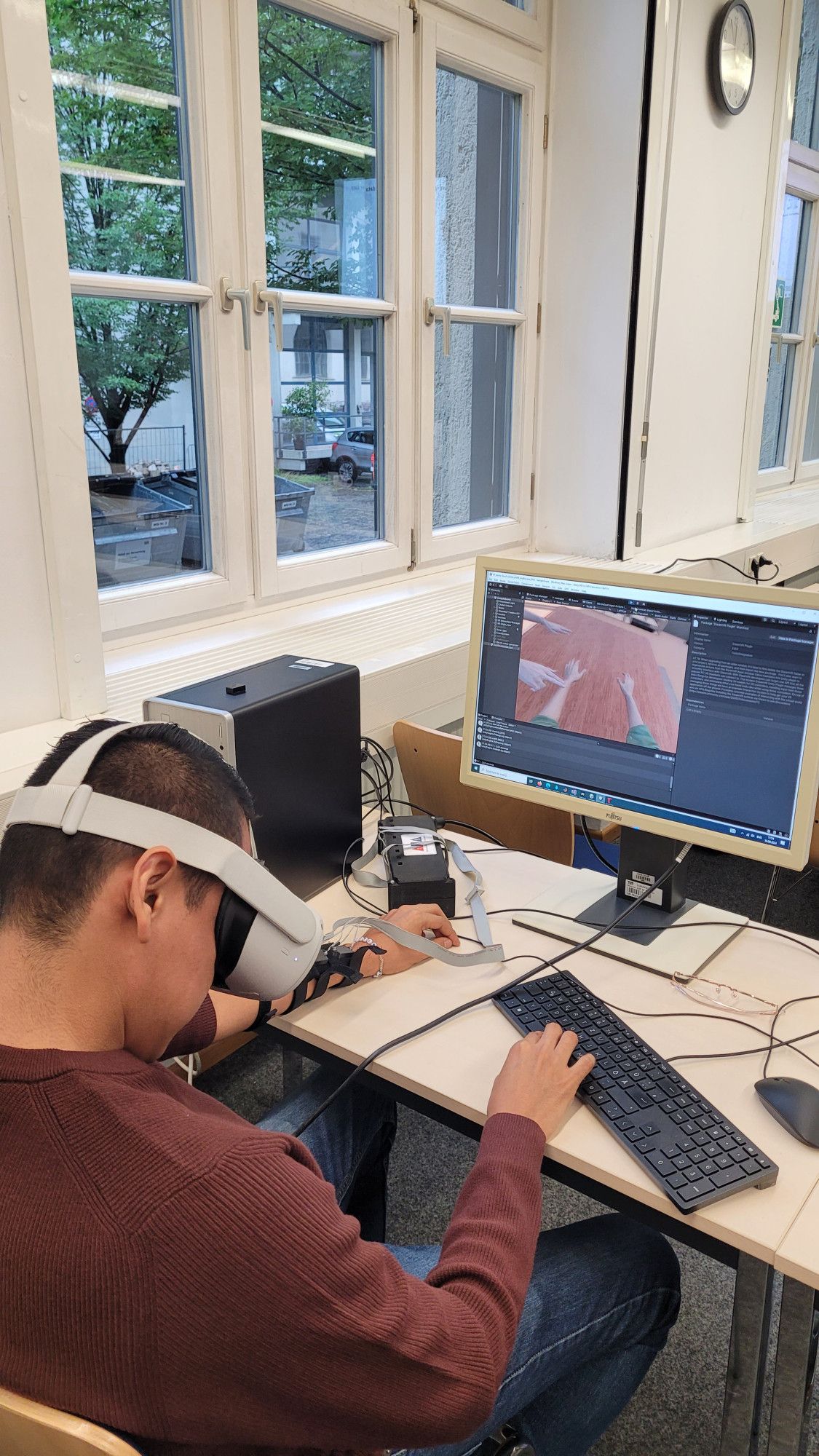 Participant wearing VR glasses and a haptic sleeve trying the social-touch VR demo