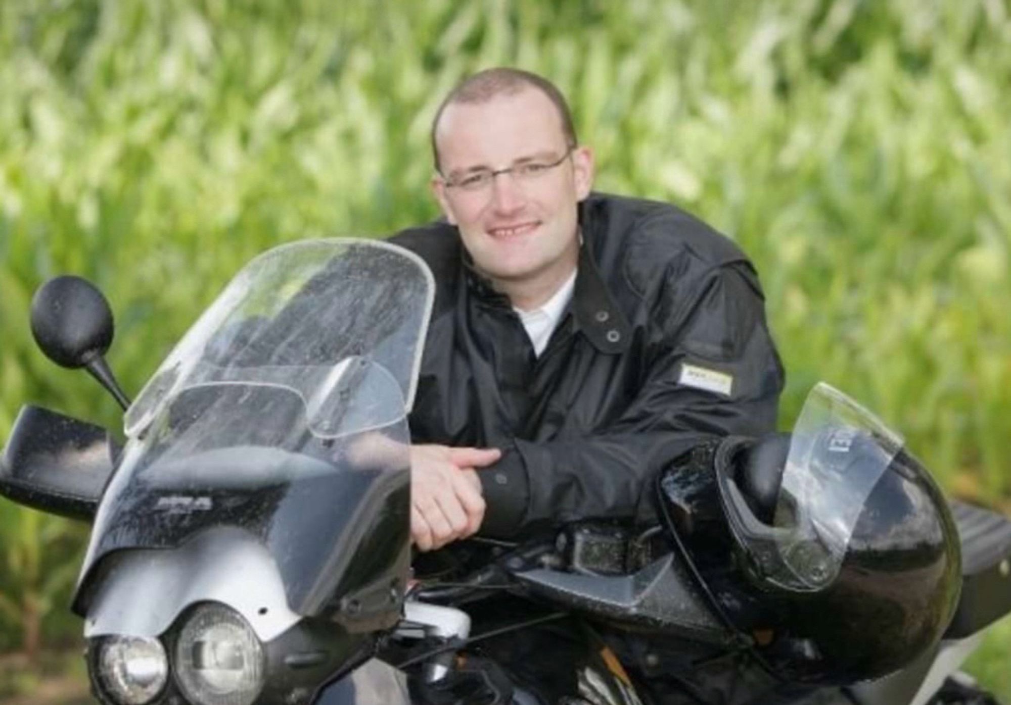 Jens Spahn in schwarzer Motorradkluft auf einem schwarzen Motorrad sitzend mit Blick zur Kamera.