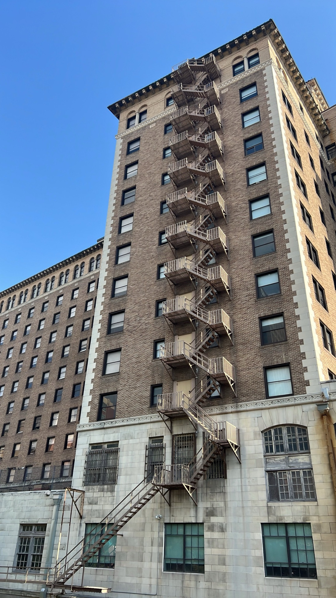 A fire escape zig zags across 10 floors of a building, cutting it in half vertically visually