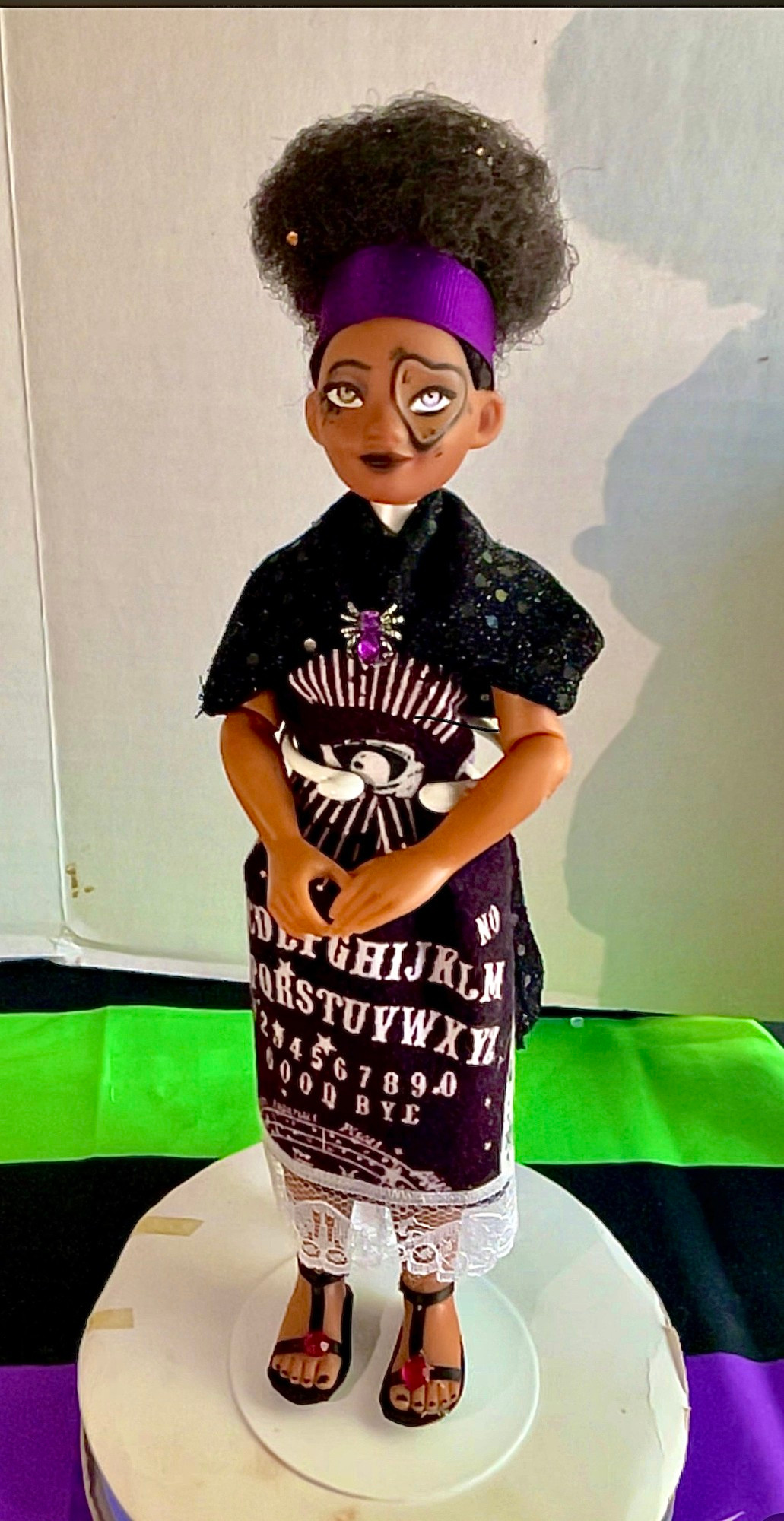 A customized doll depicting a black woman with a ouija themed design