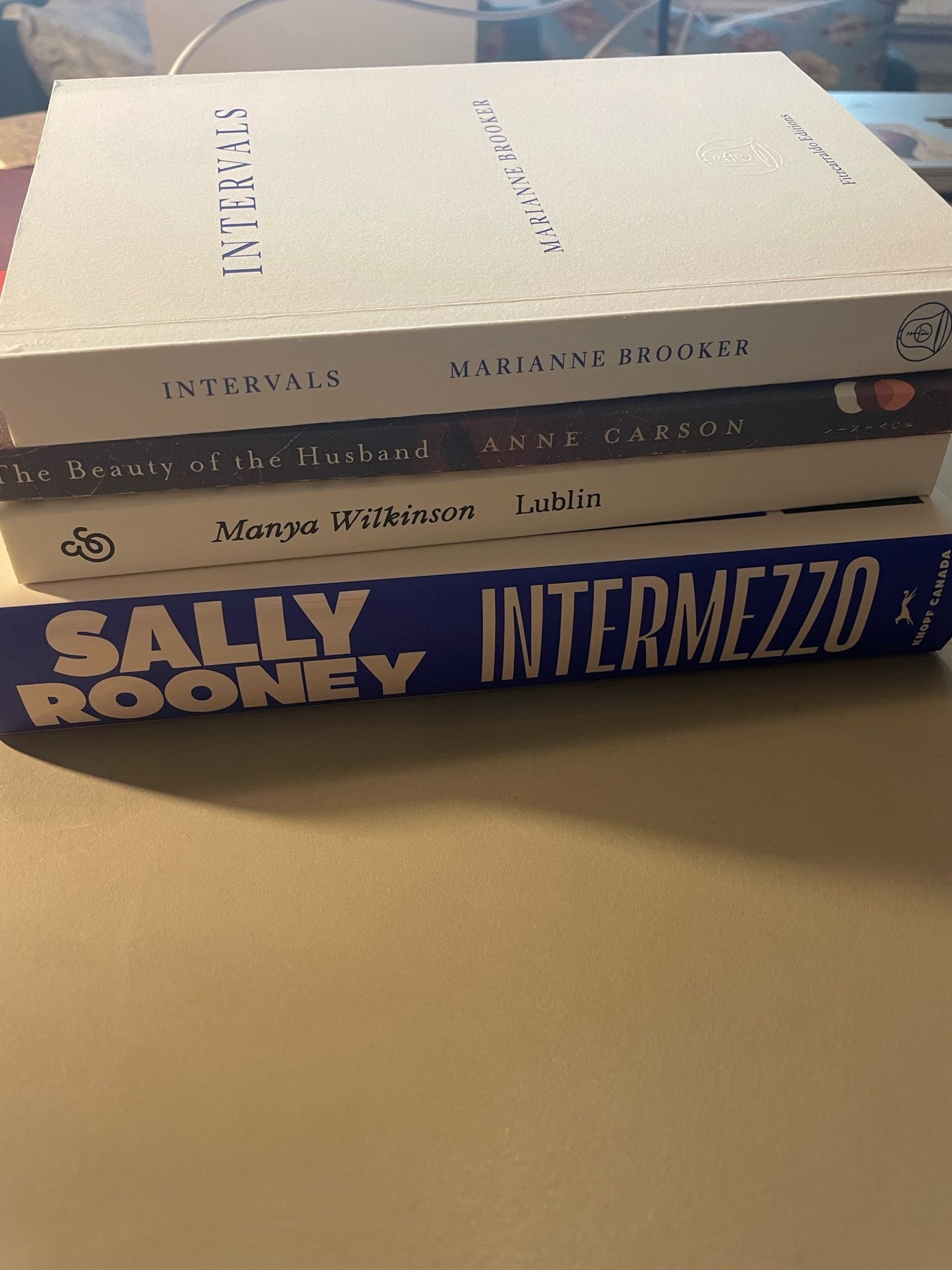 Book stack with Sally Rooney’s Intermezzo on the bottom : also Marianne Brooker’s Intervals; Anne Carson’s The Beauty of the Husband; & Maya Wilkinson’s Lublin