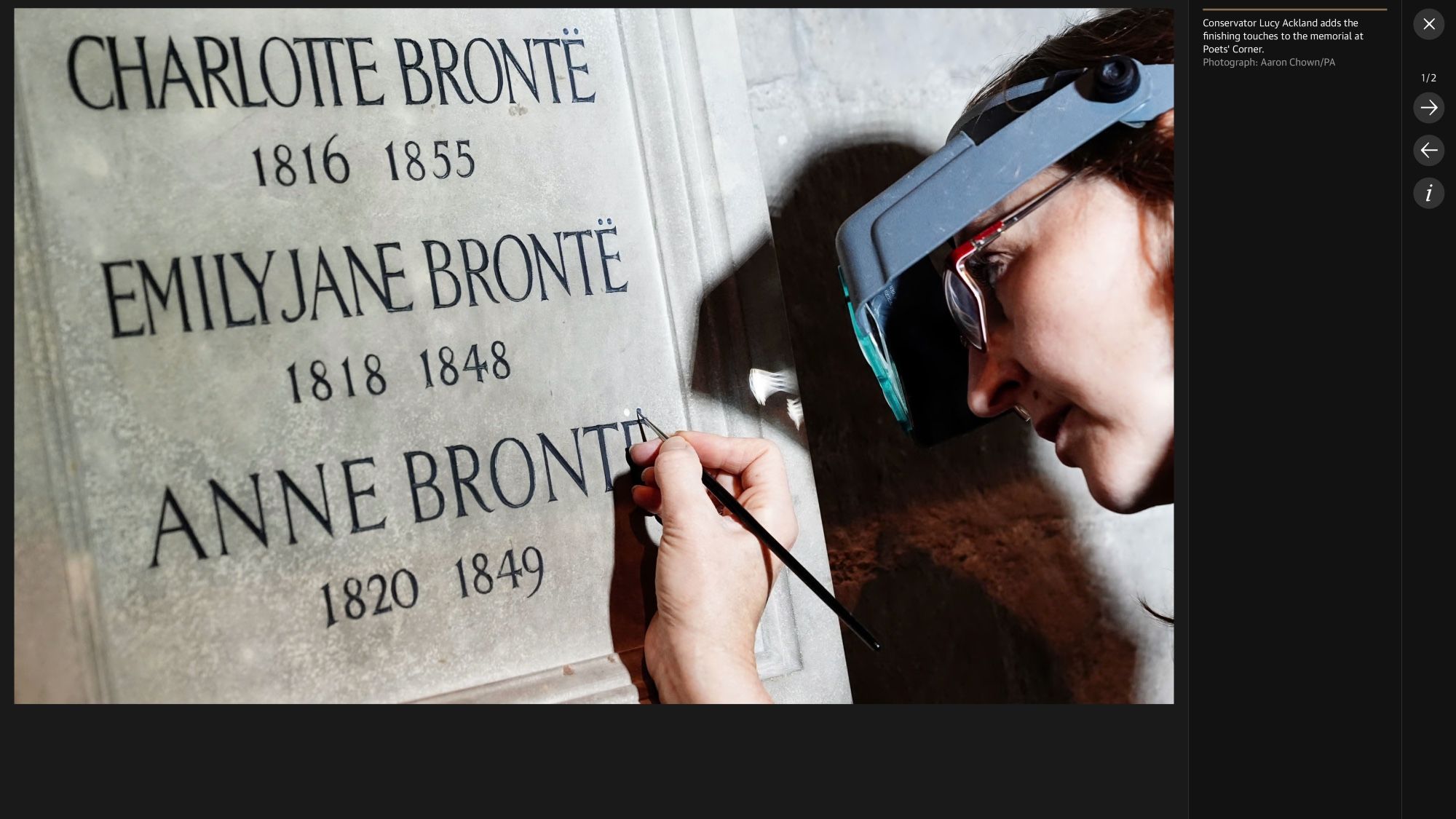 Goggled conservator belatedly adding the diaereses to the Brontës' names on their monument at Poets' Corner in Westminster Abbey.