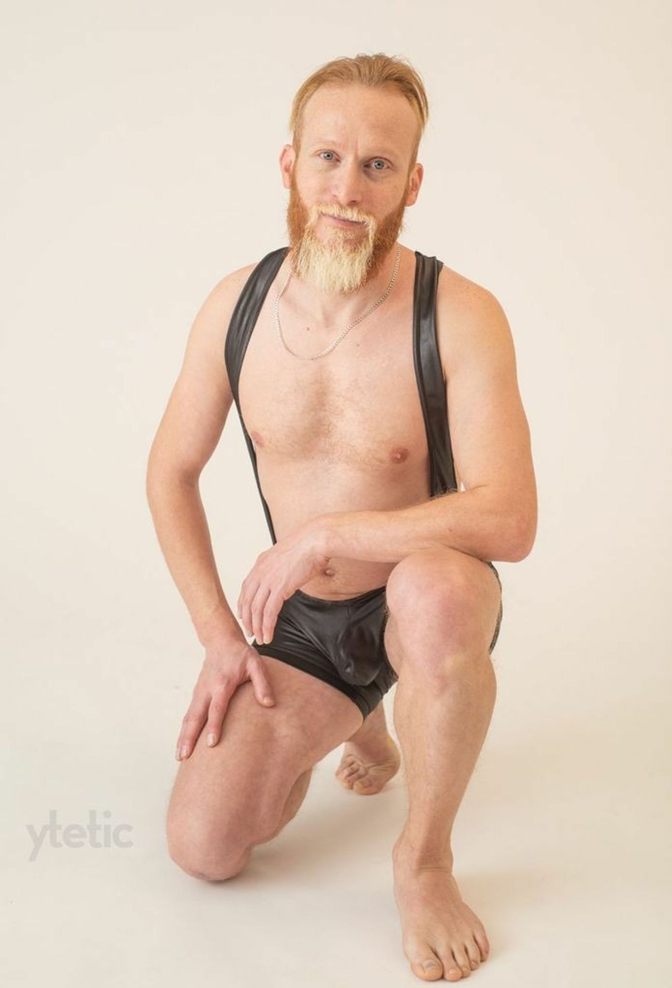 Four colour photos, high key, white studio BG. 1. Kneeling, wearing a black singlet.