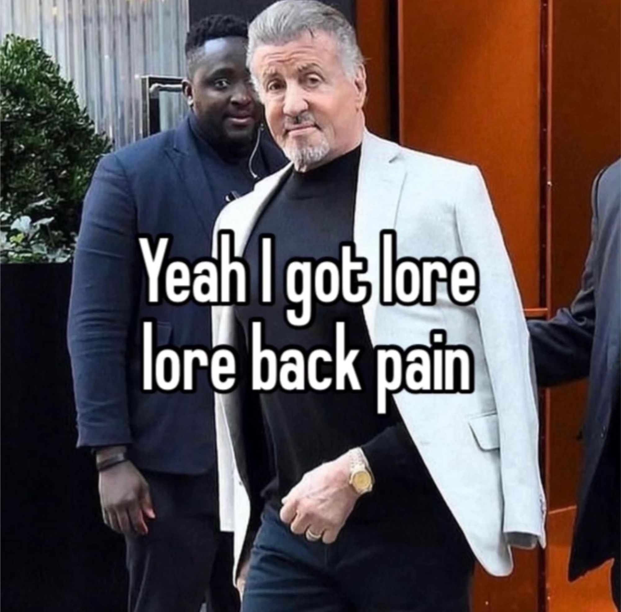 A picture of Sylvester Stallone walking while looking at the camera, a caption says “Yeah I got lore, lore back pain”