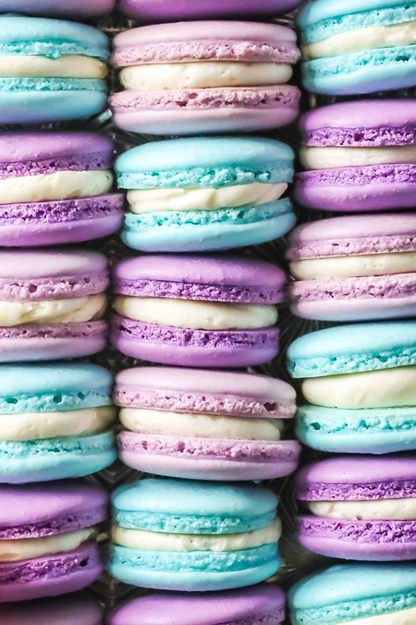 Purple and teal macarons with white icing inside