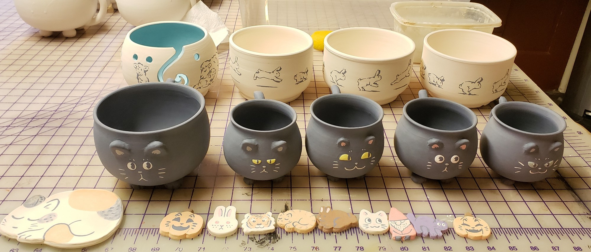 kitty mugs, bunny planters, a yarn bowl, small plate and magnets