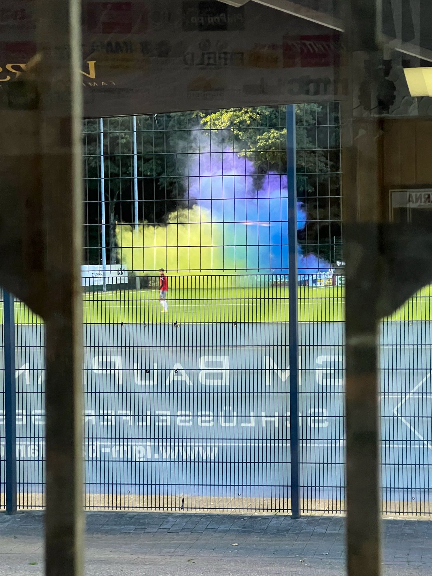 Vredener Fußballraudis zünden auf der Jule-Ludorf Sportanlage zwei Rauchtöpfe in der Farbe blau und gelb.