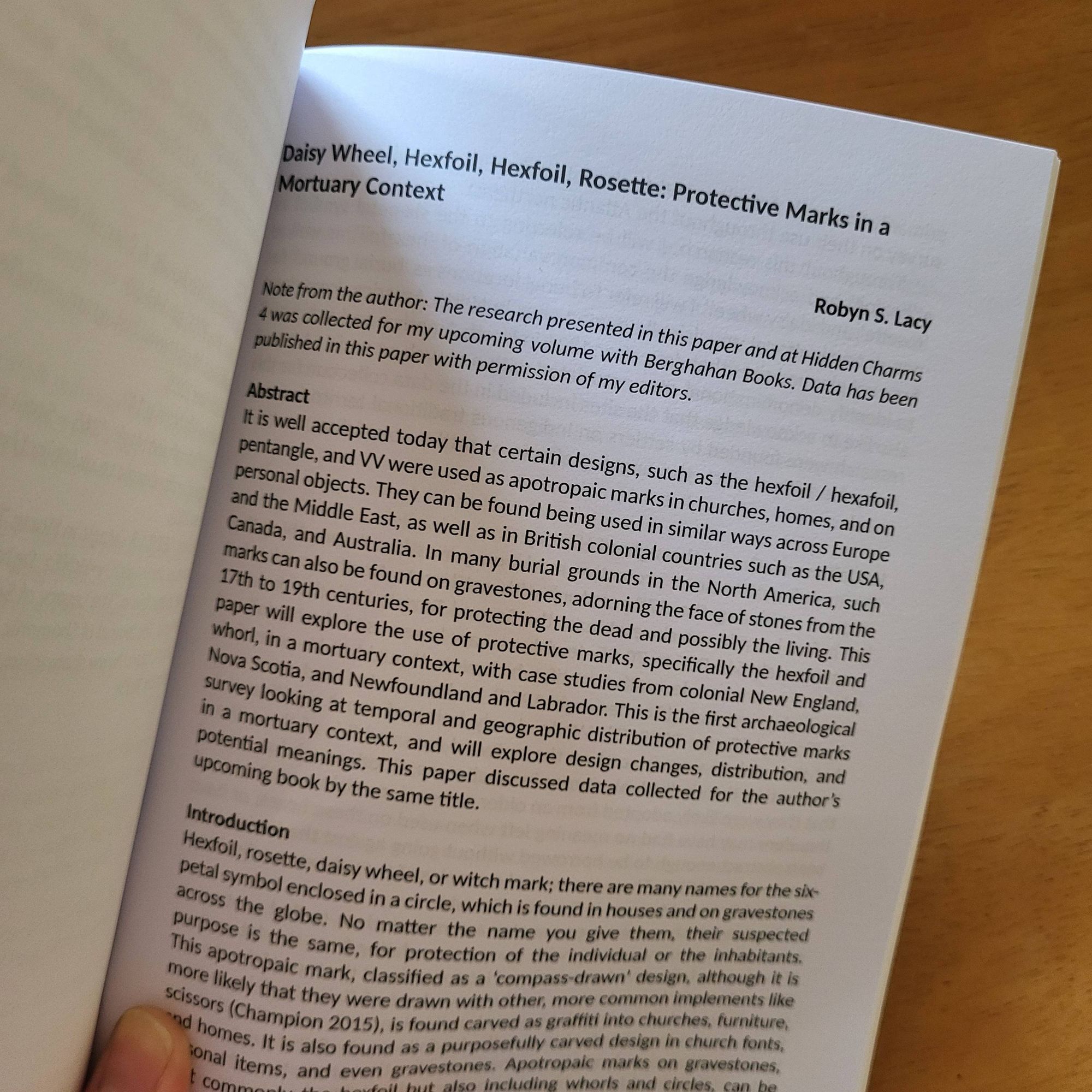 Interior photo of a page of the book, of the first page of my article! The article is called 'Daisy wheel, hexfoil, hexfoil, rosette: protective marks in a mortuary context'.