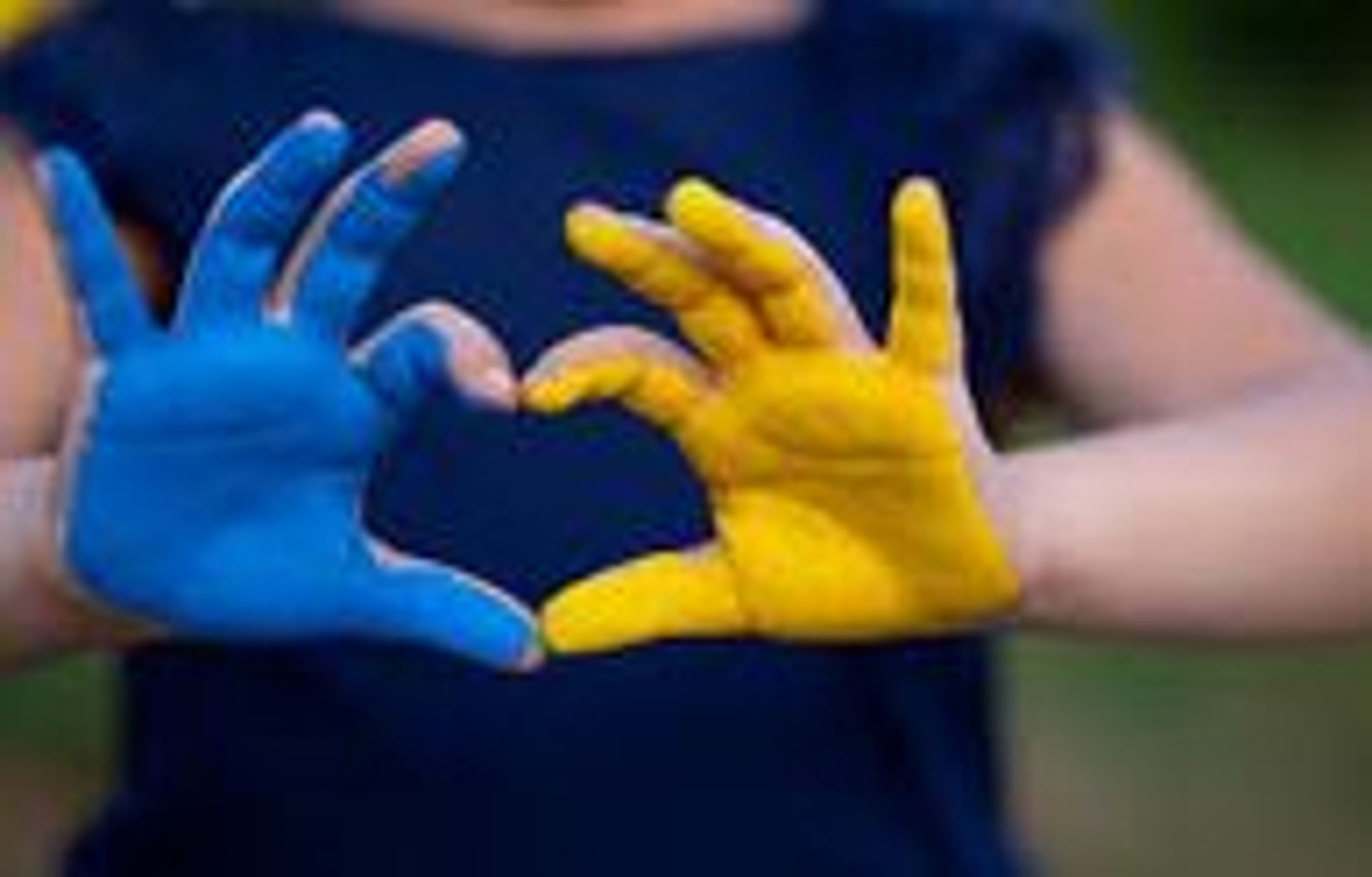 Ein blaue und eine gelbe Hand formen ein Herz. 
Es sind die Landesfarben der Ukraine