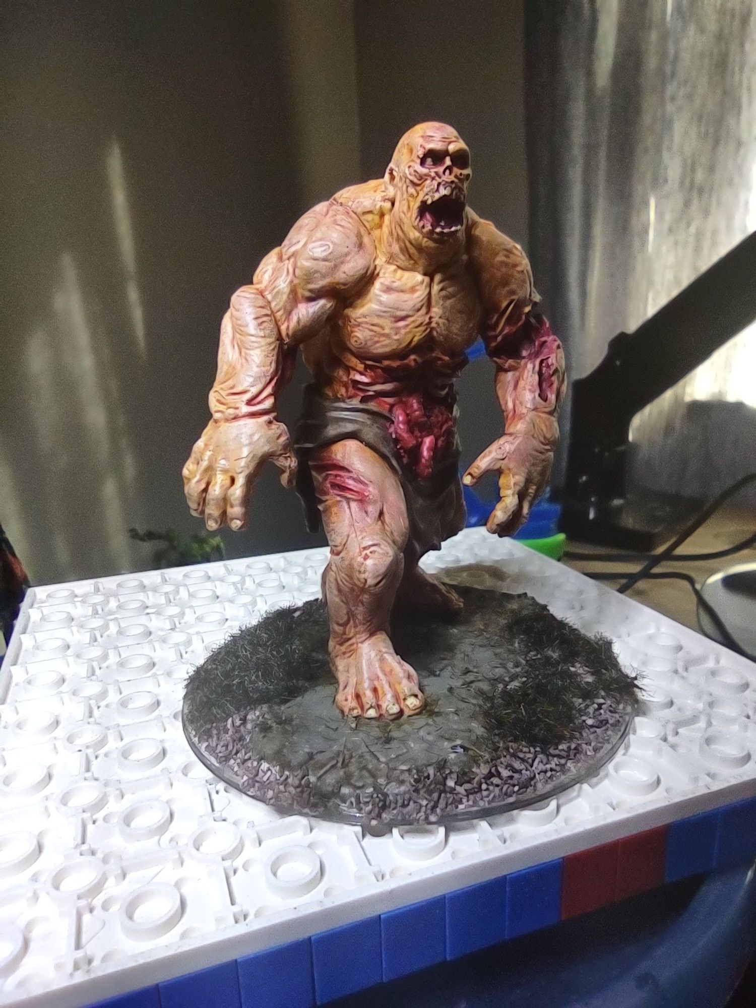 A large undead figure in lurching pose with entrails spilling out