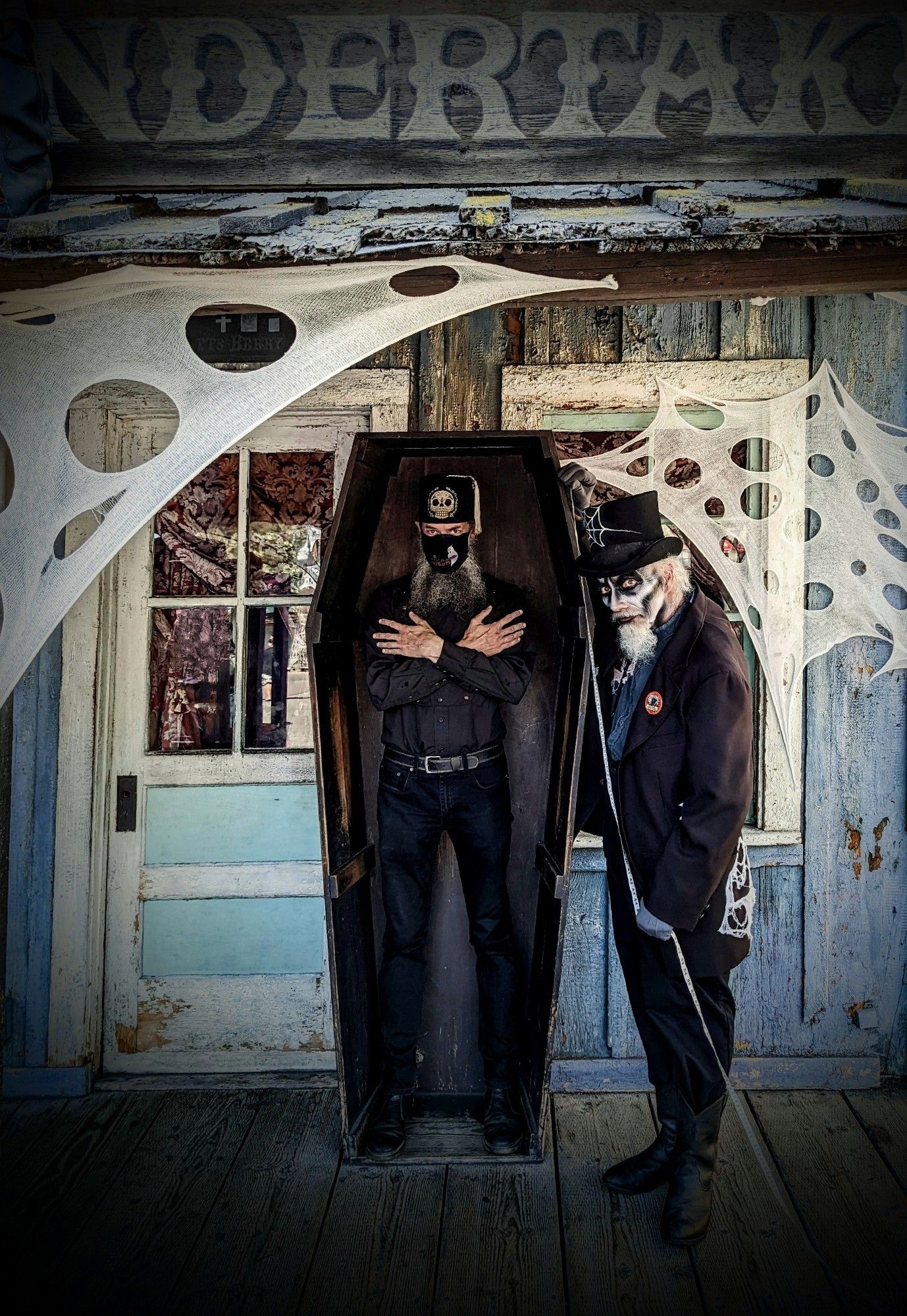 I am standing in a classic toe-pincher wooden coffin with my arms crossed while a spectral Old West undertaker stands beside me with an unfurled measuring tape. The ghostly undertaker is a white-goateed actor in corpsepaint performing for the daytime kid-friendly "Knott's Spooky Farm" event. They should have these characters every year, but, alas, management selects otherwise.