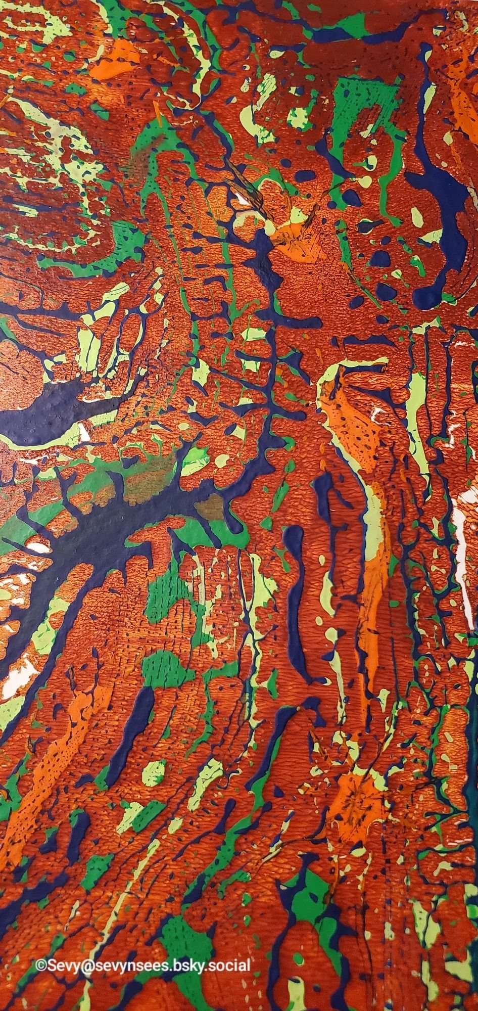 A gel plate abstract print using dark blue, green, yellow-geeen, red oxide and burnt sienna acrylic paint.