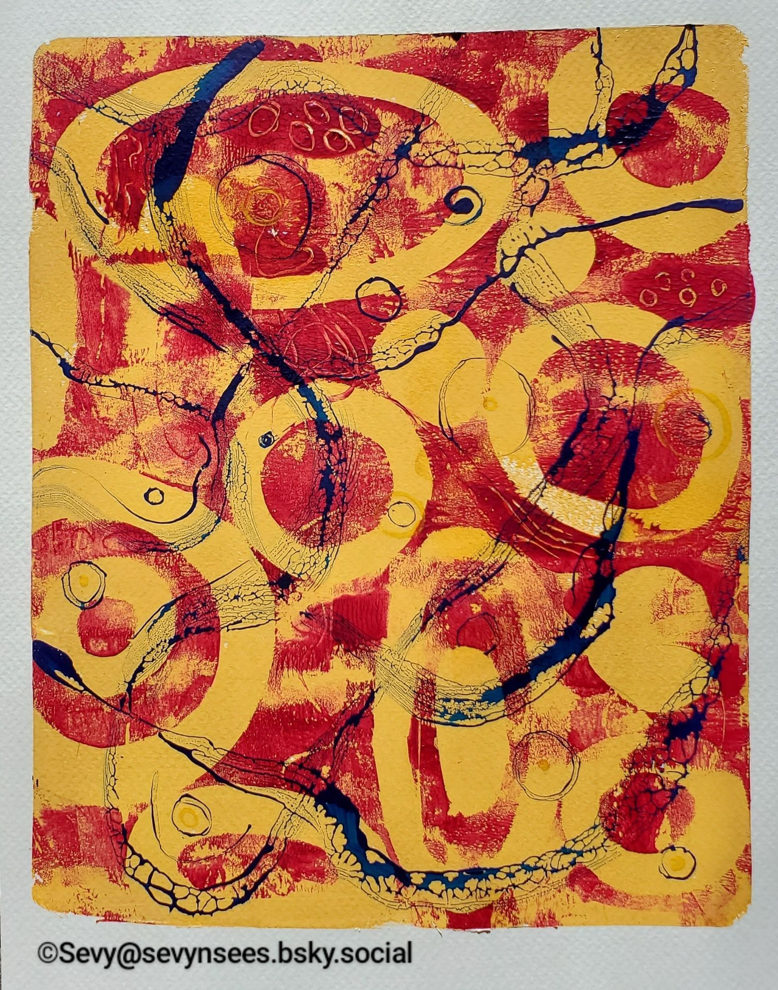 Gel plate print of yellow ovals & circles with a red background. Squiggles of dark blue run through it.