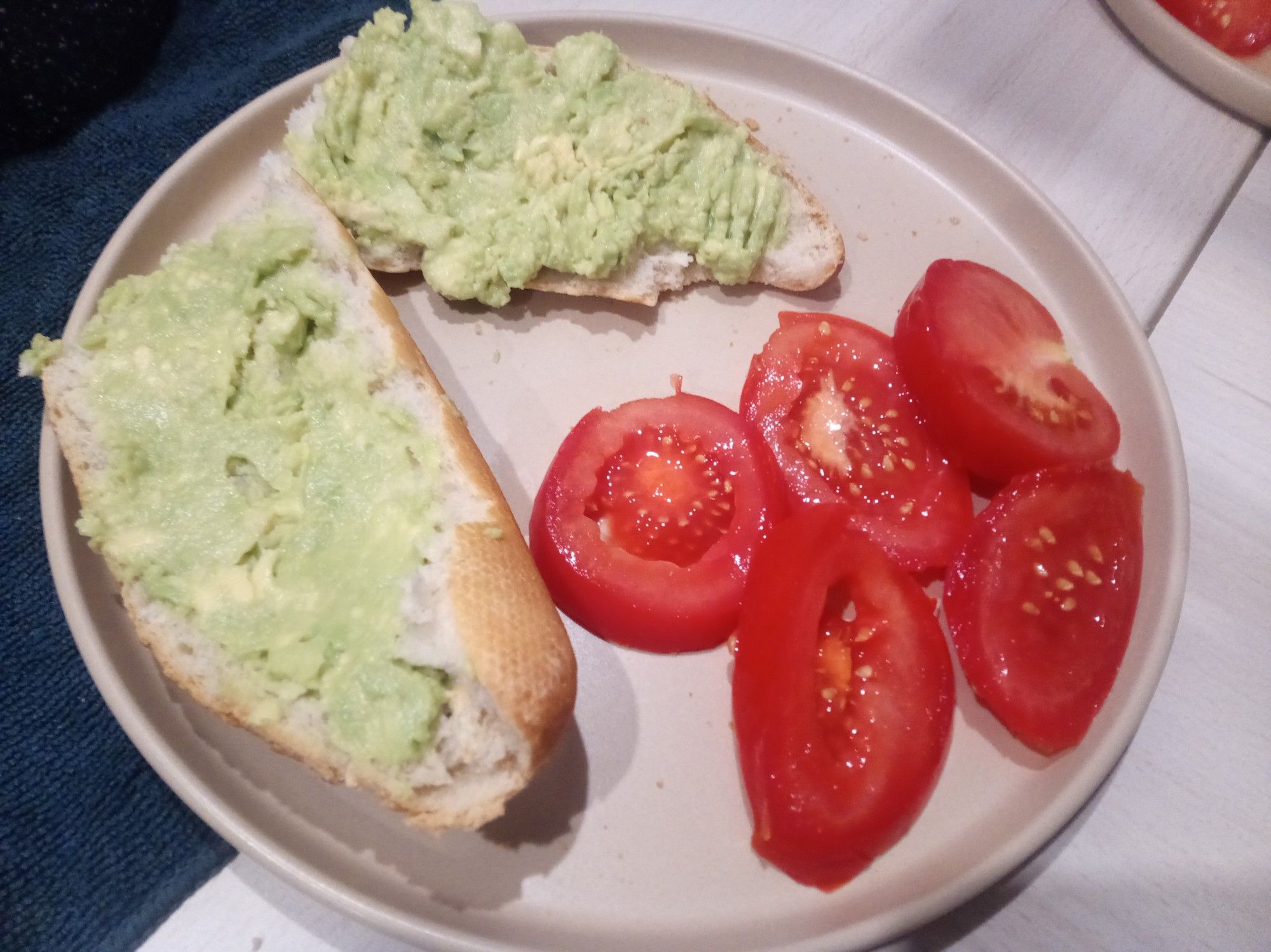 Mashed avocado smeared onto a chunk of baguette, with tomato salad on the side. Not shown, tumbler of under 5€ rosé.