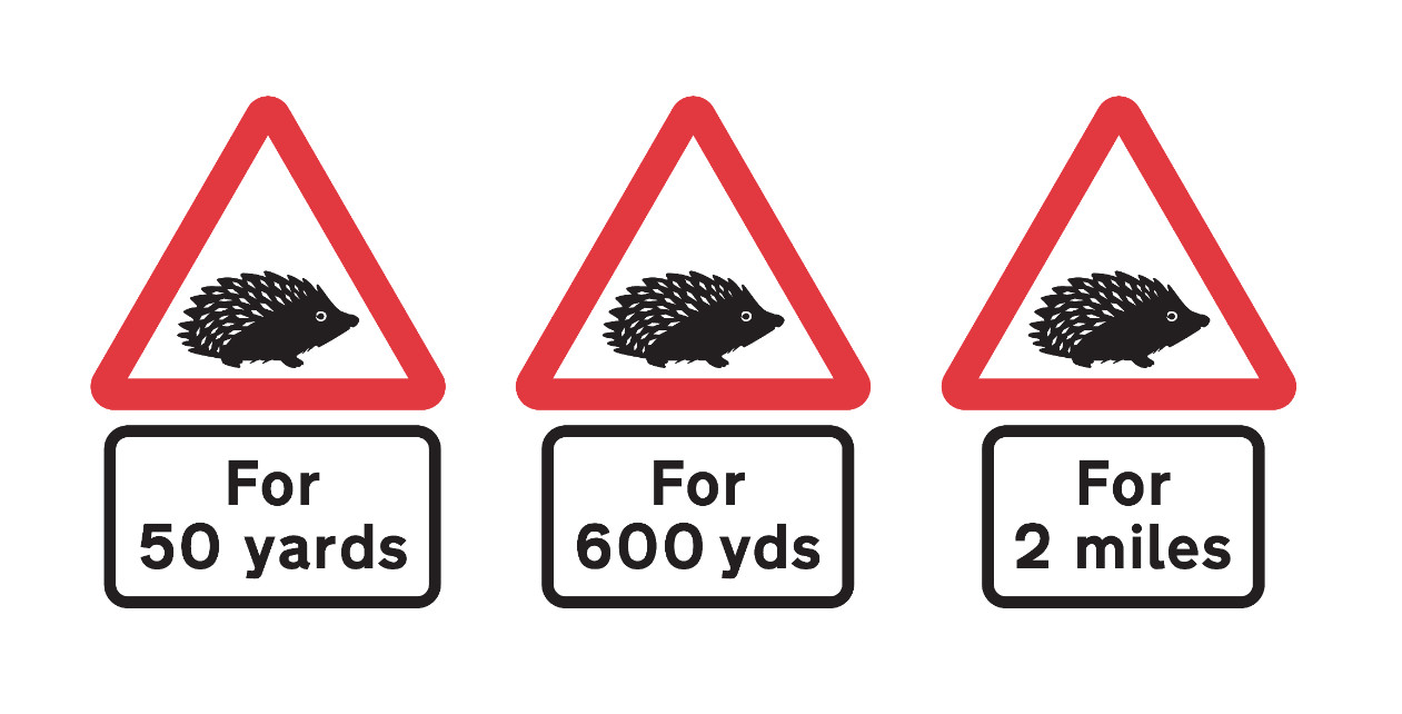 Examples of red triangle warning signs with a hedgehog and 50/600 yards and 2 miles underplates. 