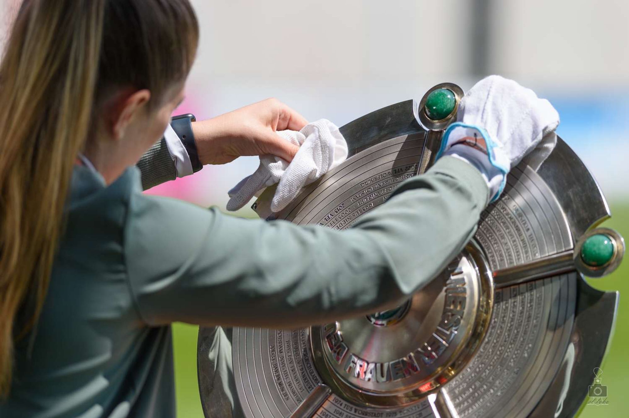 Eine MItarbeiterin des DFB putzt die Meisterschale der Frauen vor der Partie des FC Bayern München gegen Tirbine Potsdam, 2022/23