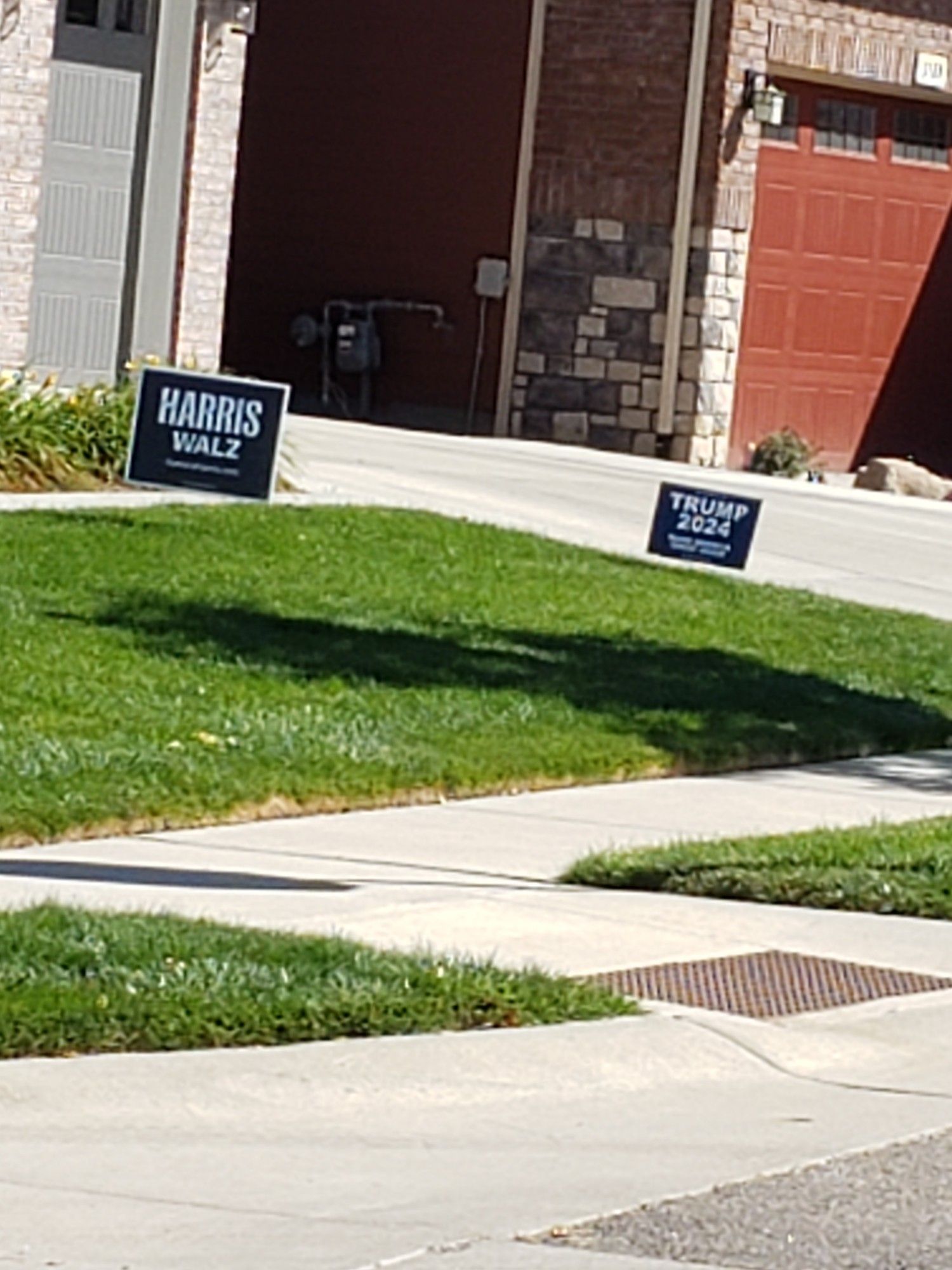 A suburban house with both a Harris Walz and a Trump Vance sign in the yard.