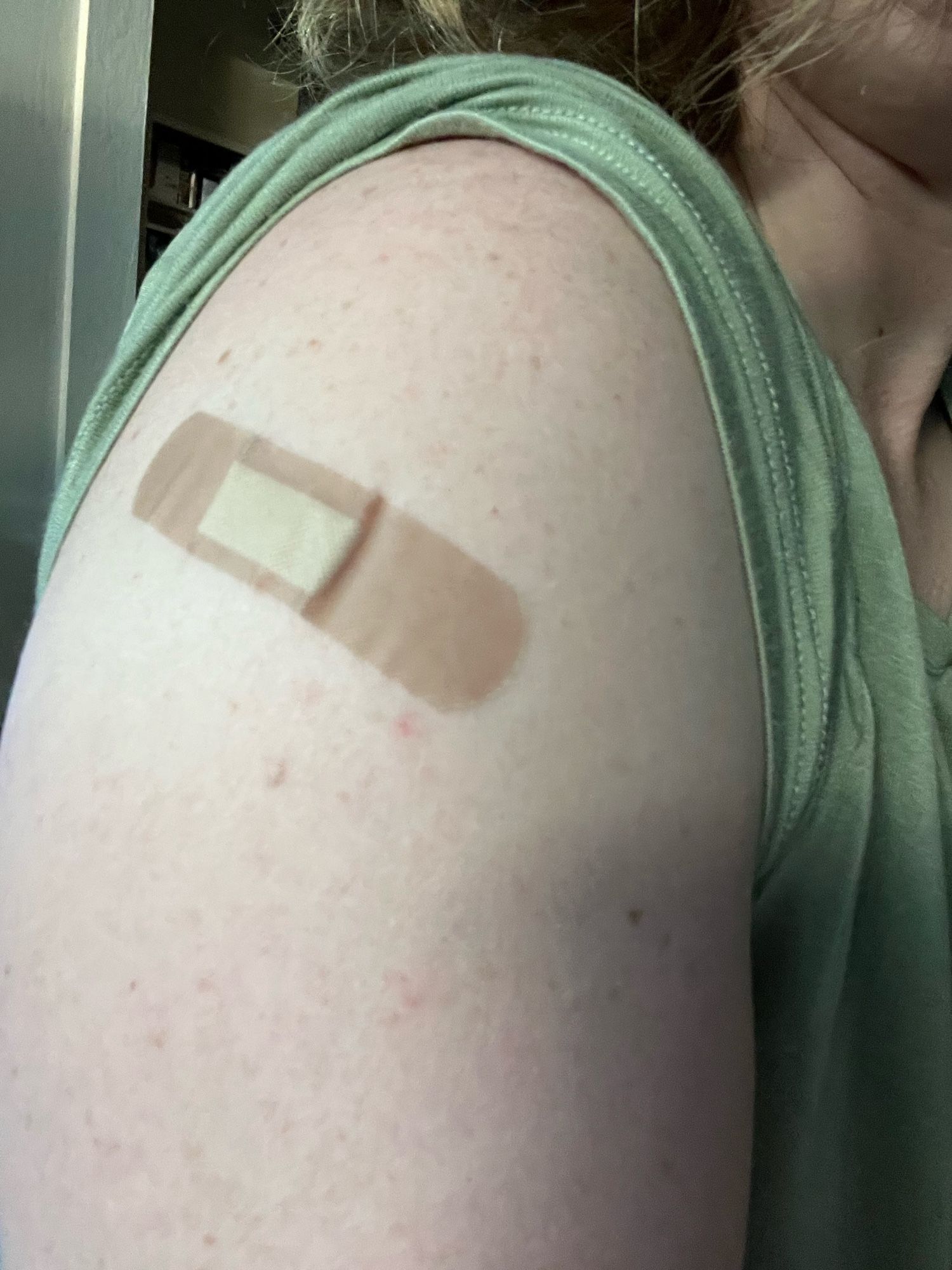 A right upper arm with a band aid.