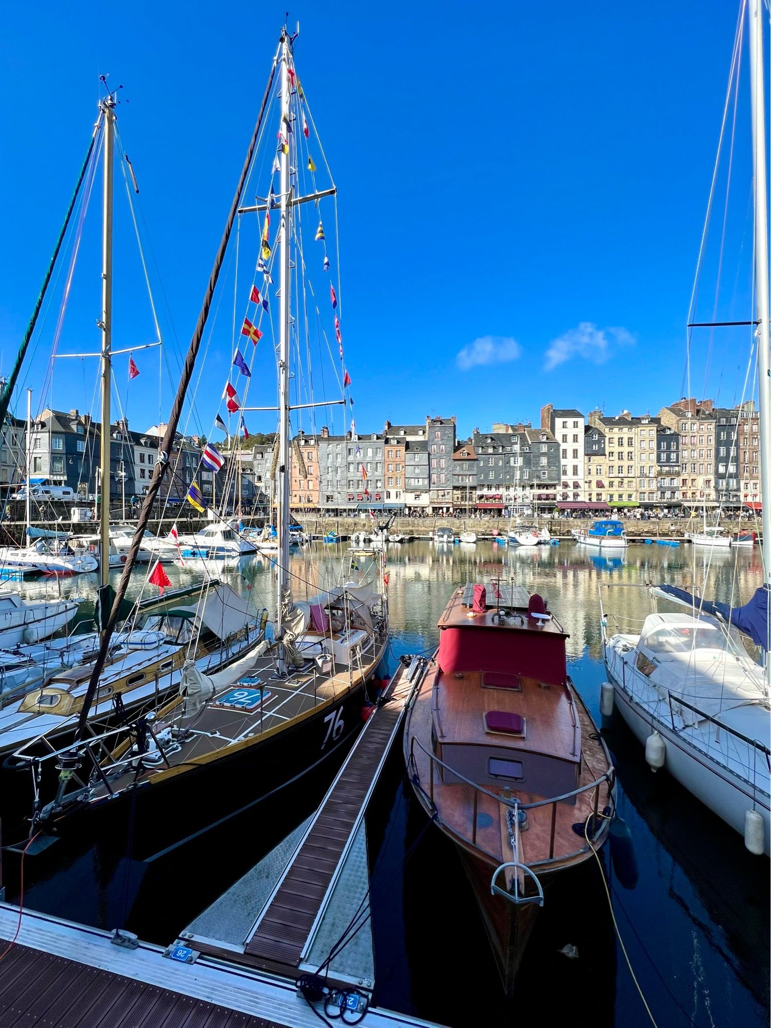 Vieux bassin de Honfleur avec les bateaux et les immeubles qui se reflètent dans l’eau