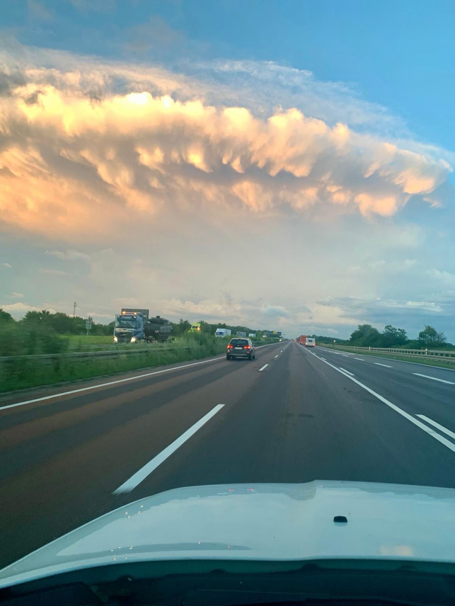 Über einer dreispurigen Autobahn türmt sich eine bedrohliche Wolkenmasse