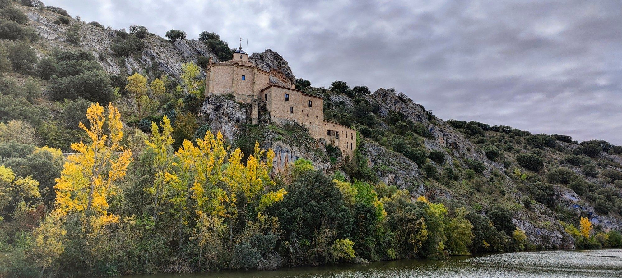 Vista de la ermita de San Saturio un día de verano con cielo de tormenta.